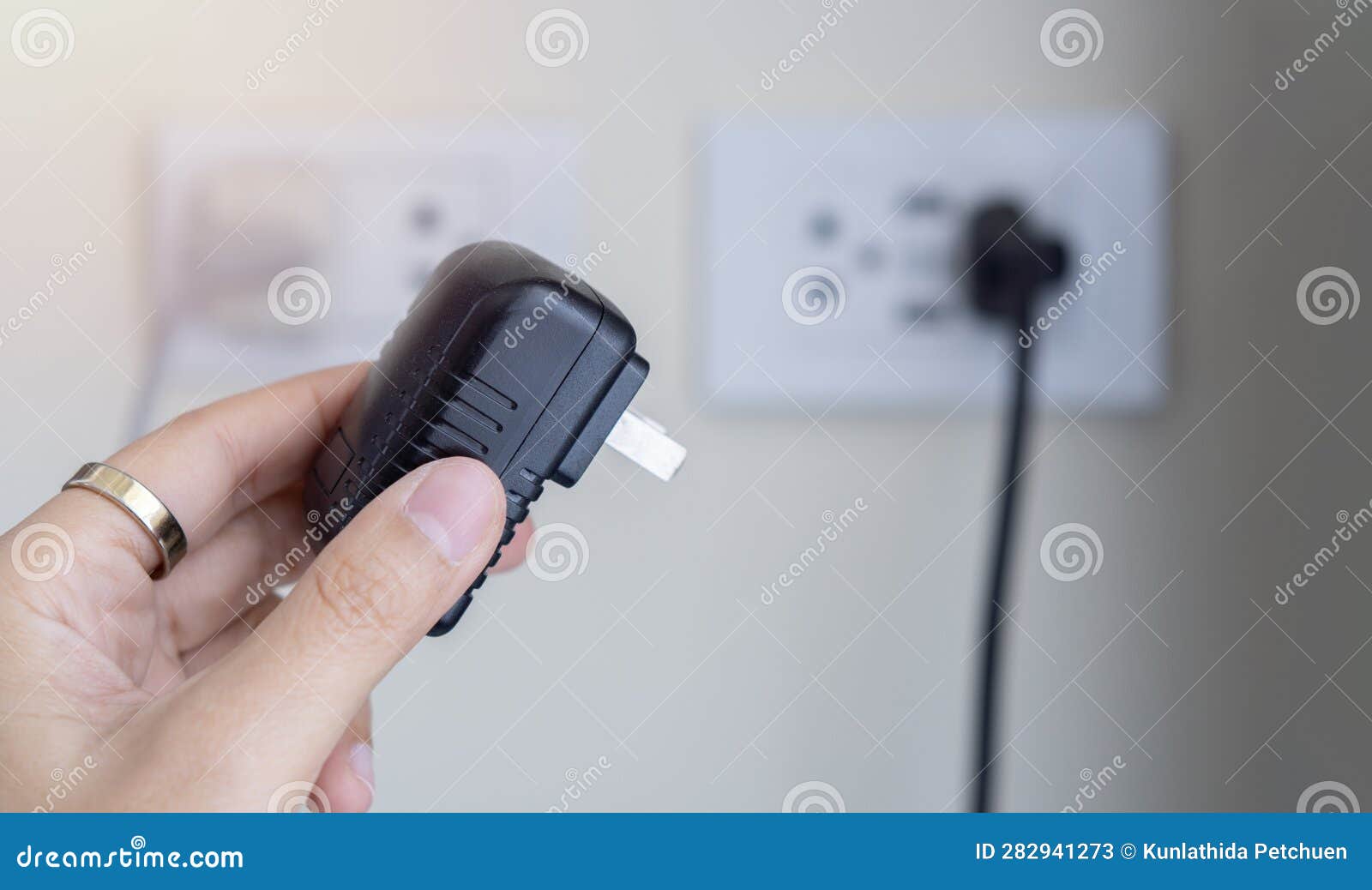 Plugging a Black Electrical Plug with a Woman S Hand into a White