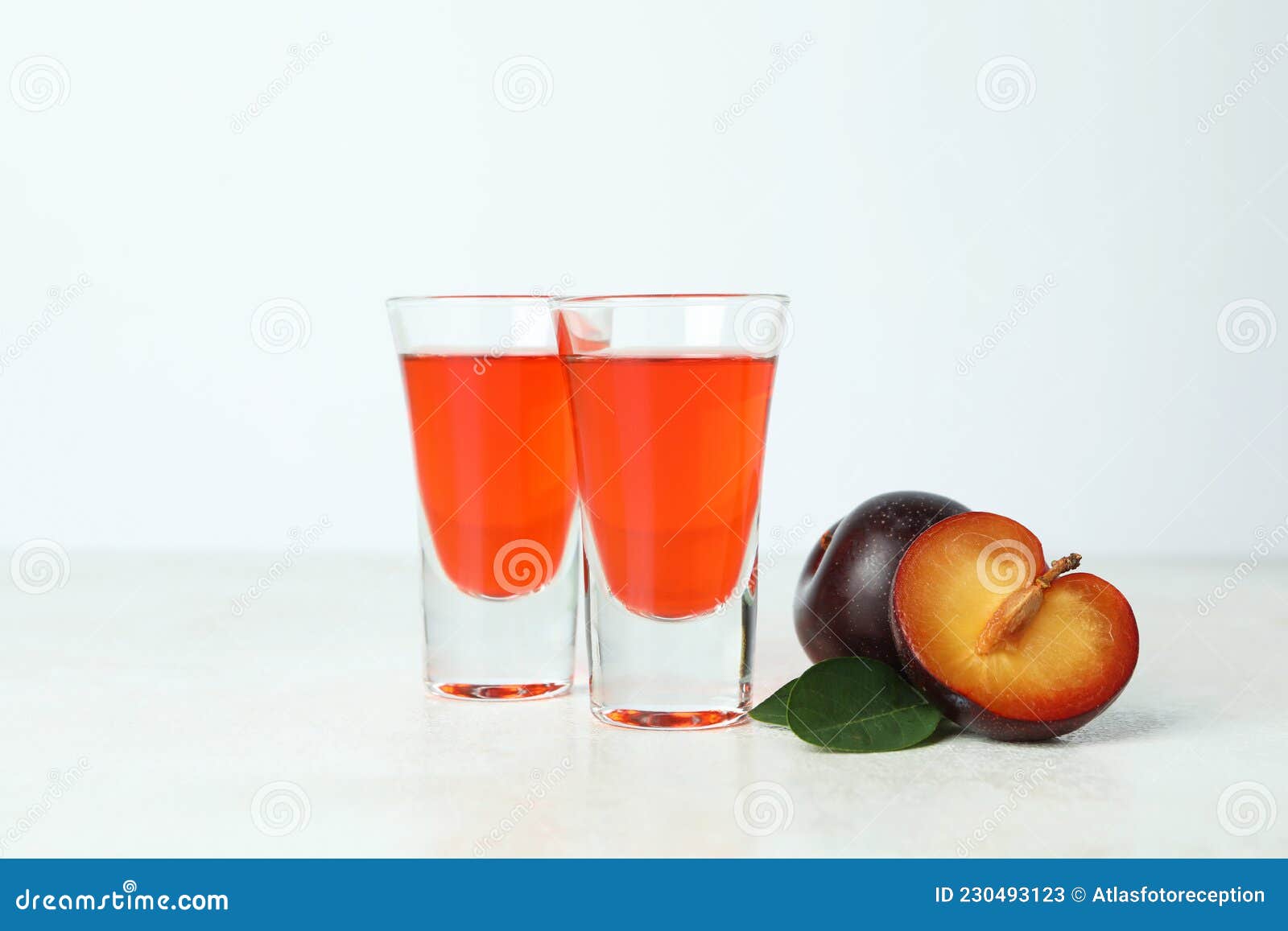 Plum Brandy Shots and Ingredients on White Textured Table Stock Image