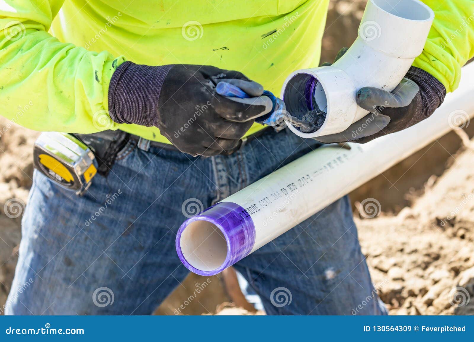 plumber applying pipe cleaner, primer and glue to pvc pipes