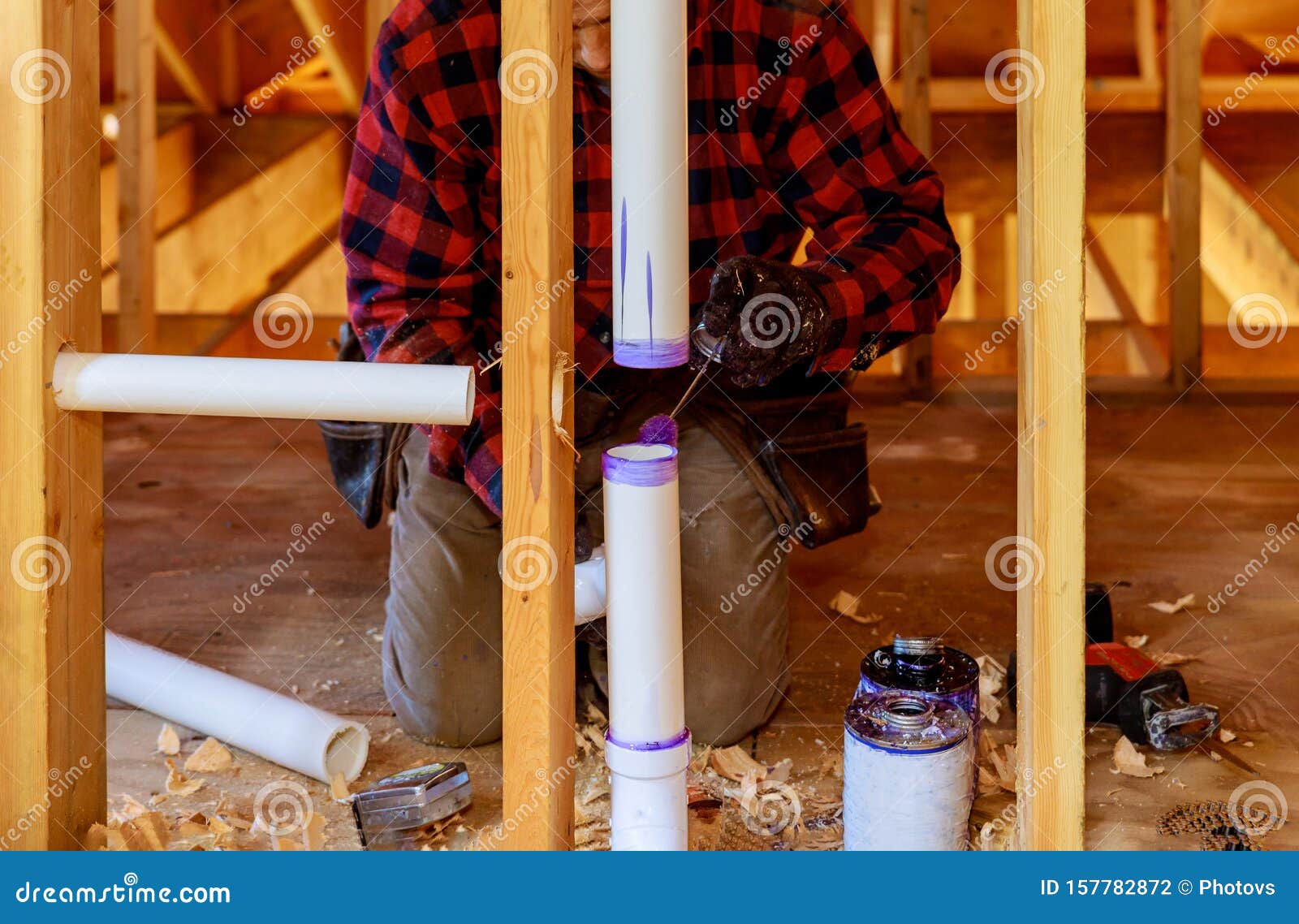 a plumber applying primer and glue a pvc pipe drain assembly