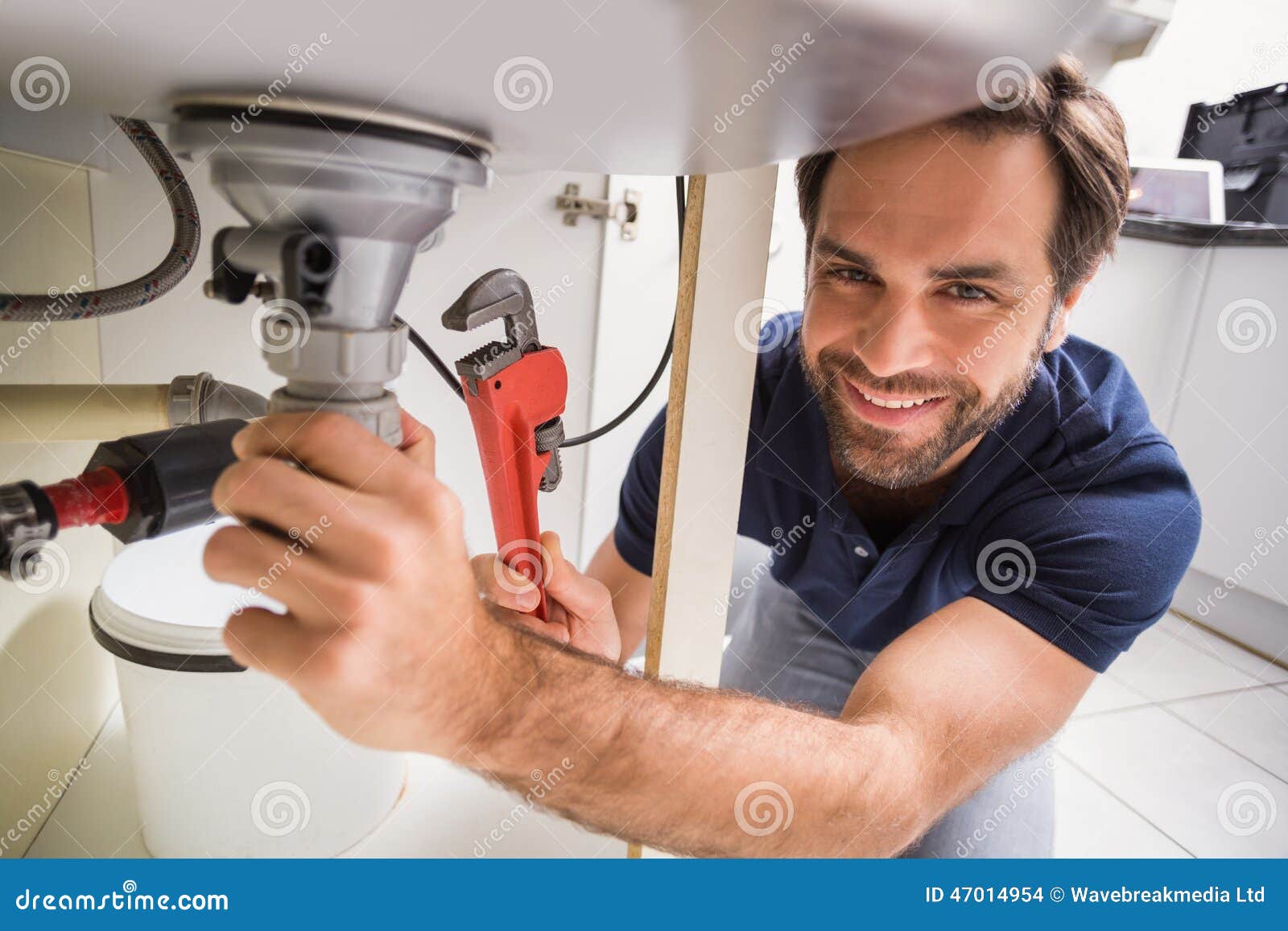 plumber-fixing-under-sink-kitchen-47014954.jpg