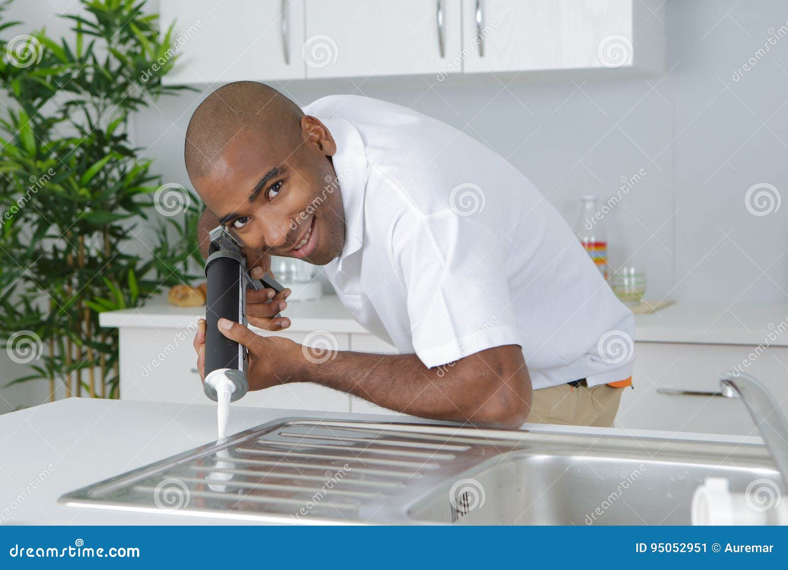 Plumber Putting Silicone Sealant To Installing Kitchen Sink Stock Image
