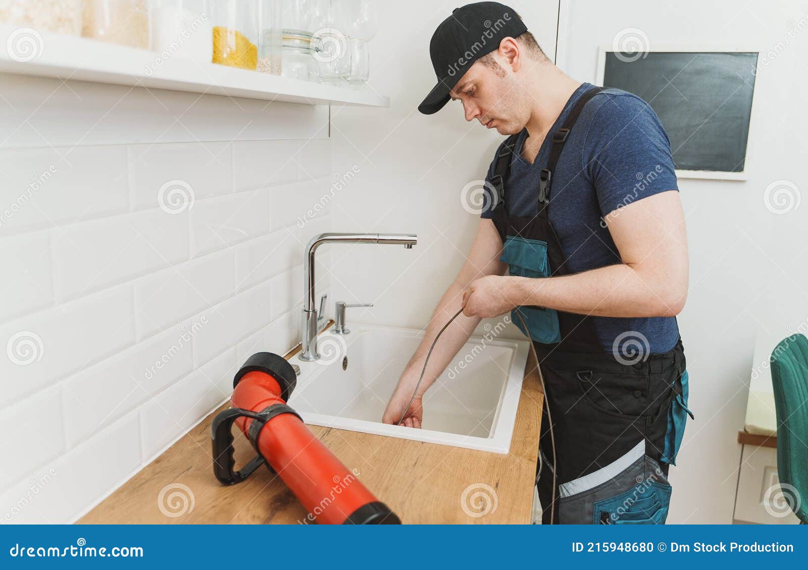 https://thumbs.dreamstime.com/z/plumber-using-drain-snake-to-unclog-kitchen-sink-215948680.jpg