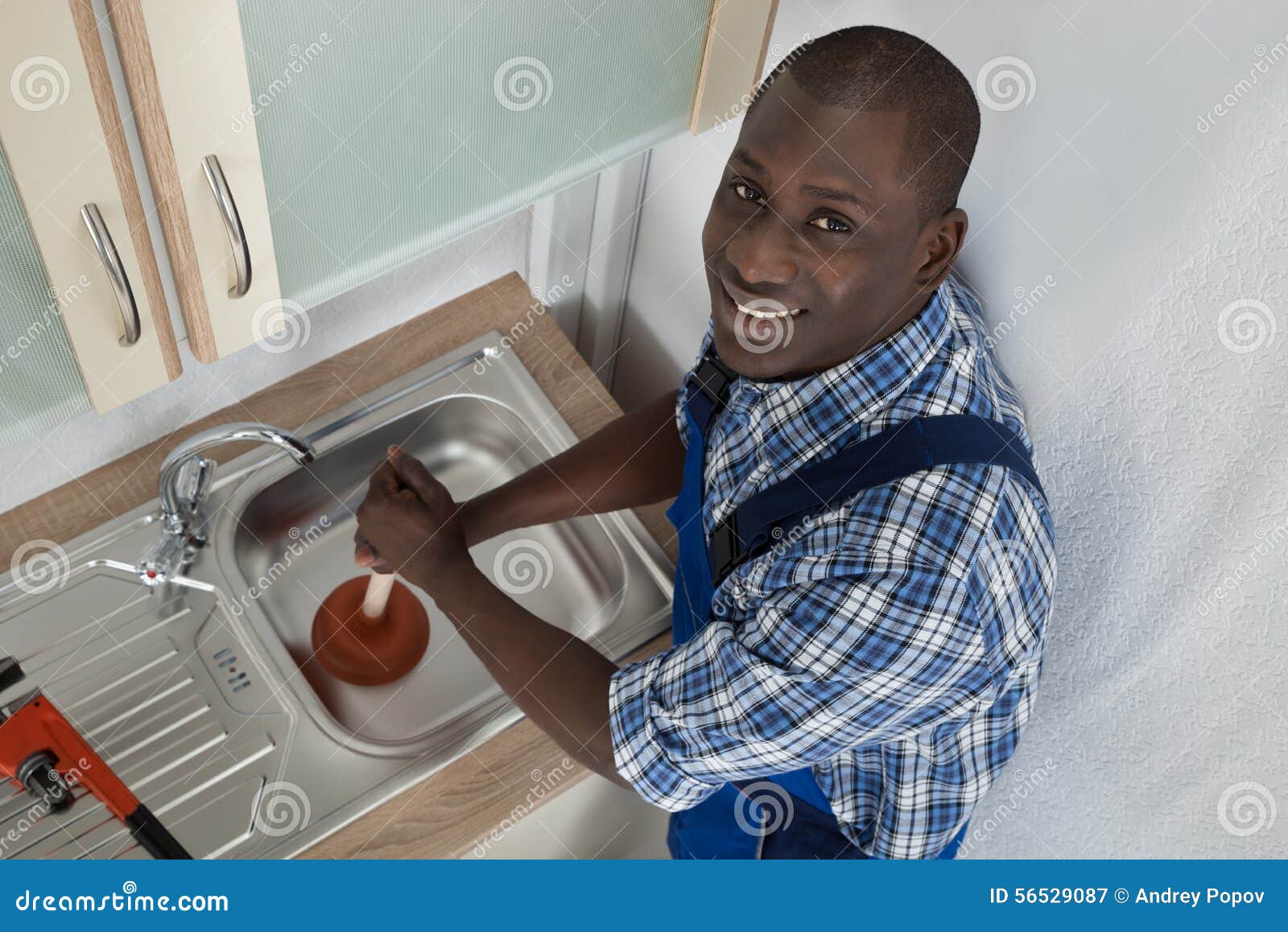 Happy Woman Looking At Male Plumber Using Plunger In The Kitchen Sink,  Stock Photo, Picture And Low Budget Royalty Free Image. Pic. ESY-048550729