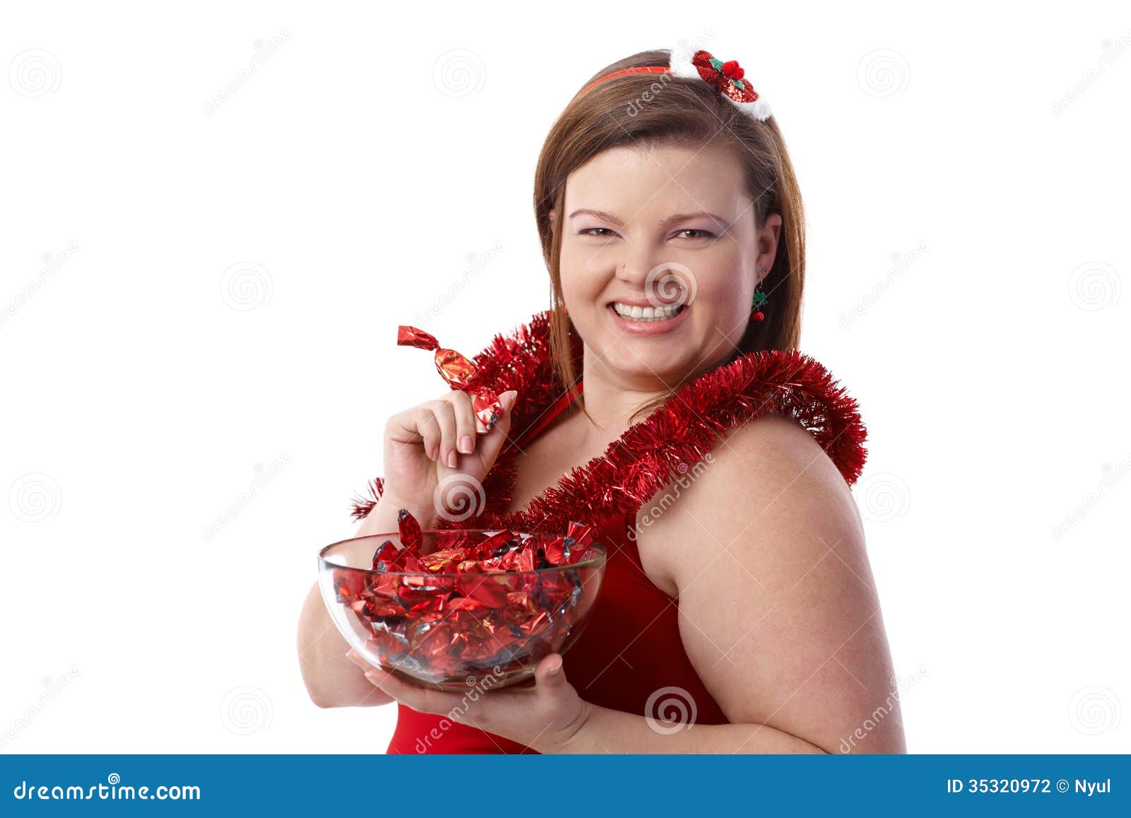 Plump woman with Christmas fondant smiling. Plump woman in red with a bowl of Christmas fondant, smiling.