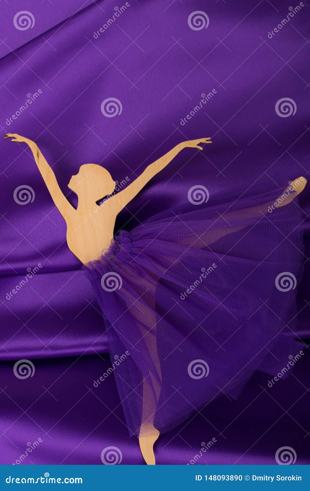 plywood ballerina figurine on purple fabric