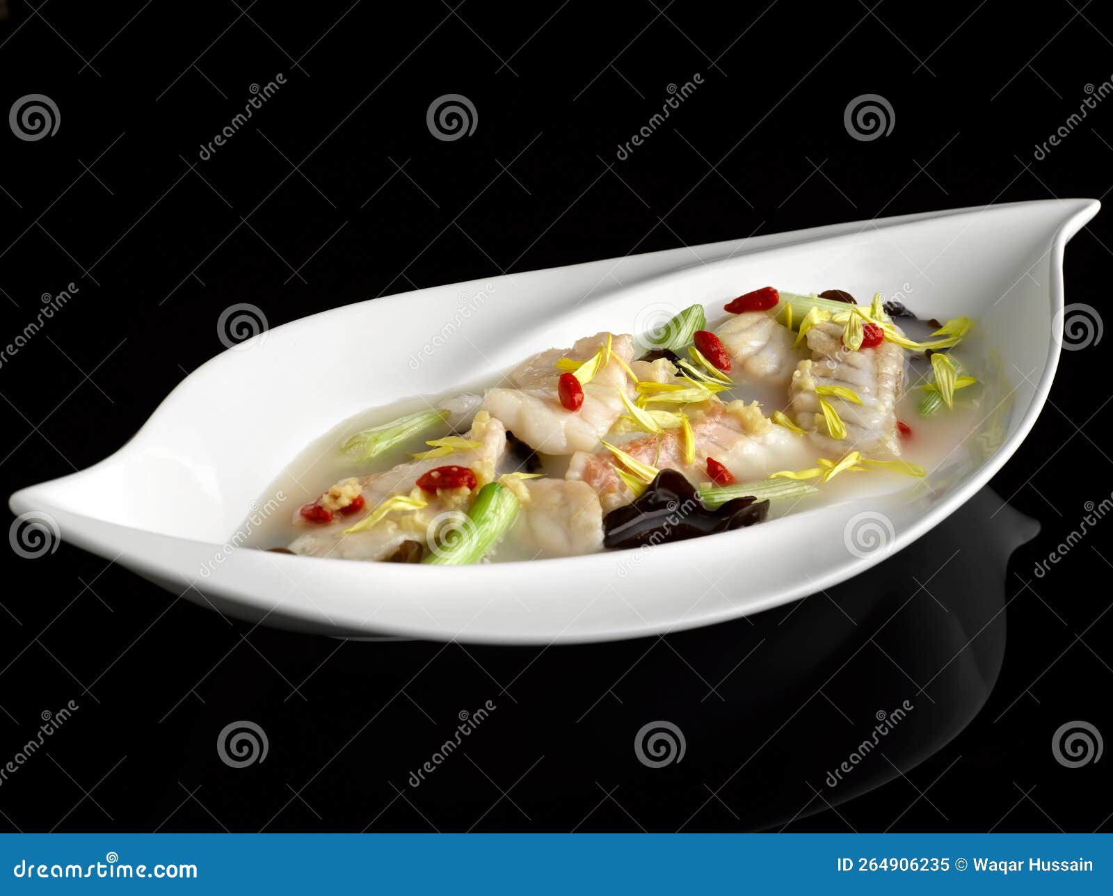 poached garoupa fillet with chrysanthemum and ginger in superior rice wine broth served dish  on background top view food