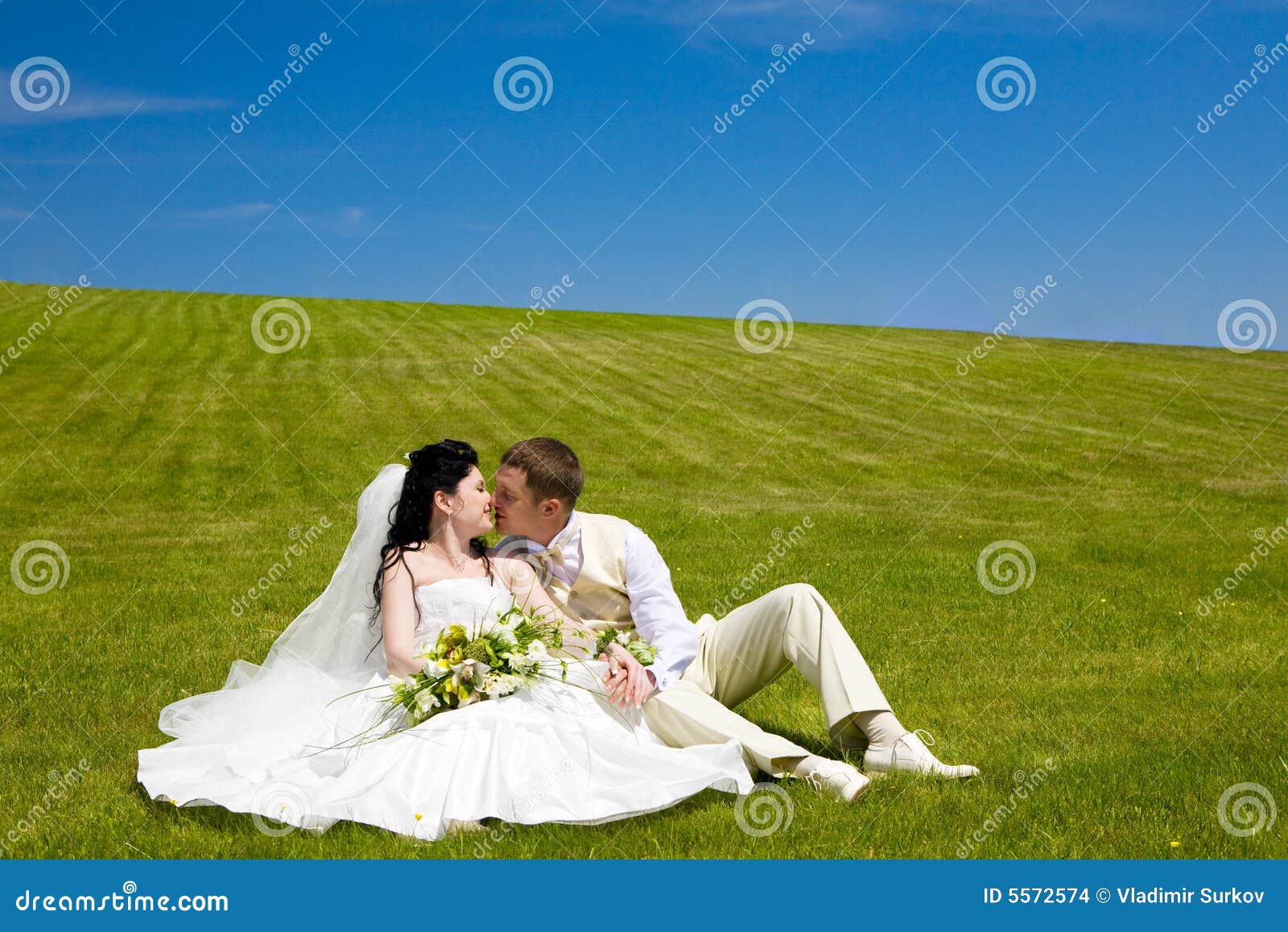 Pocałunek za parę trawy nowo. Pannę młodą trawy zielone młodego całowania