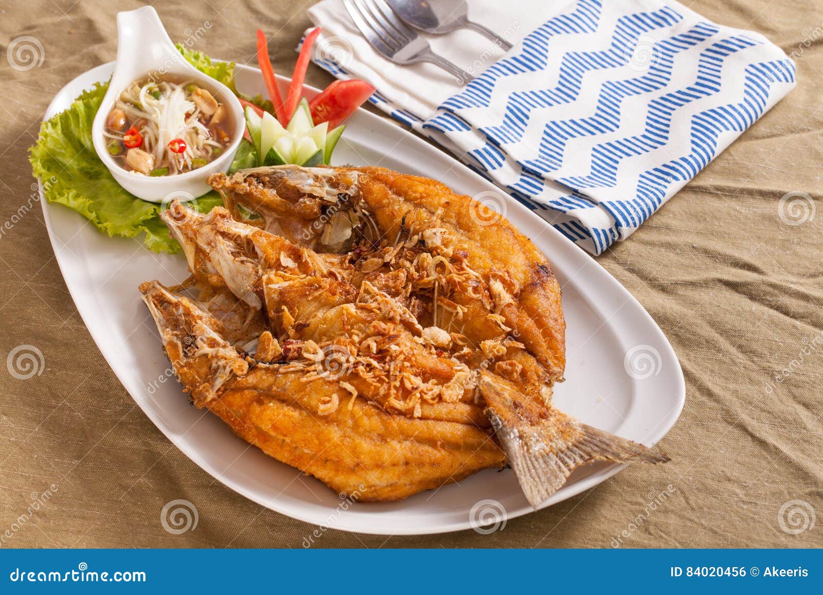 Poissons cuits à la friteuse. Un plat de style thaïlandais croustillant a cuit les poissons à la friteuse entiers de bar de mer servis avec de la sauce épicée à mangue