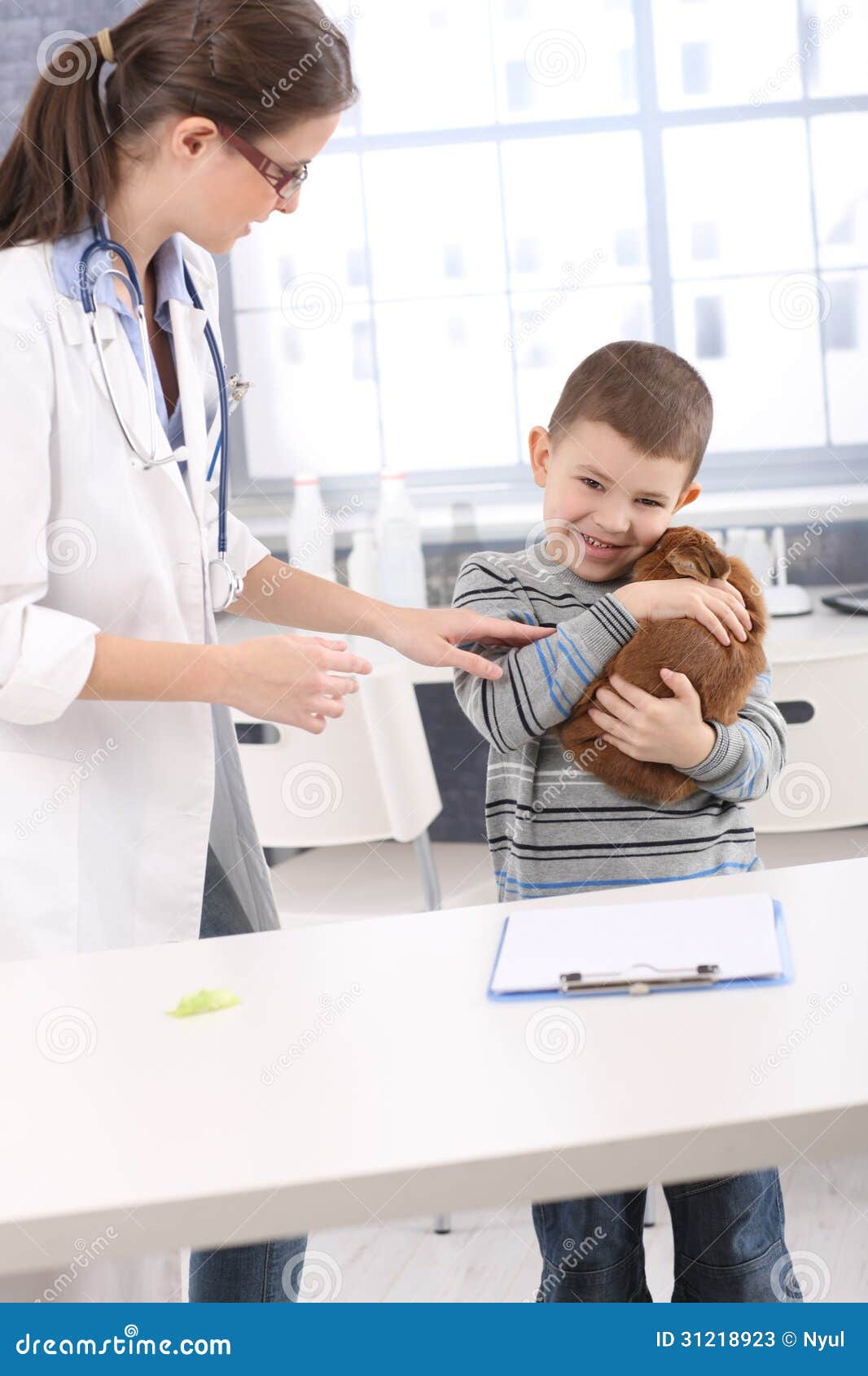 Le pojkekel med älsklings- kanin på veterinärkontoret, doktor som försöker att kontrollera djuret.