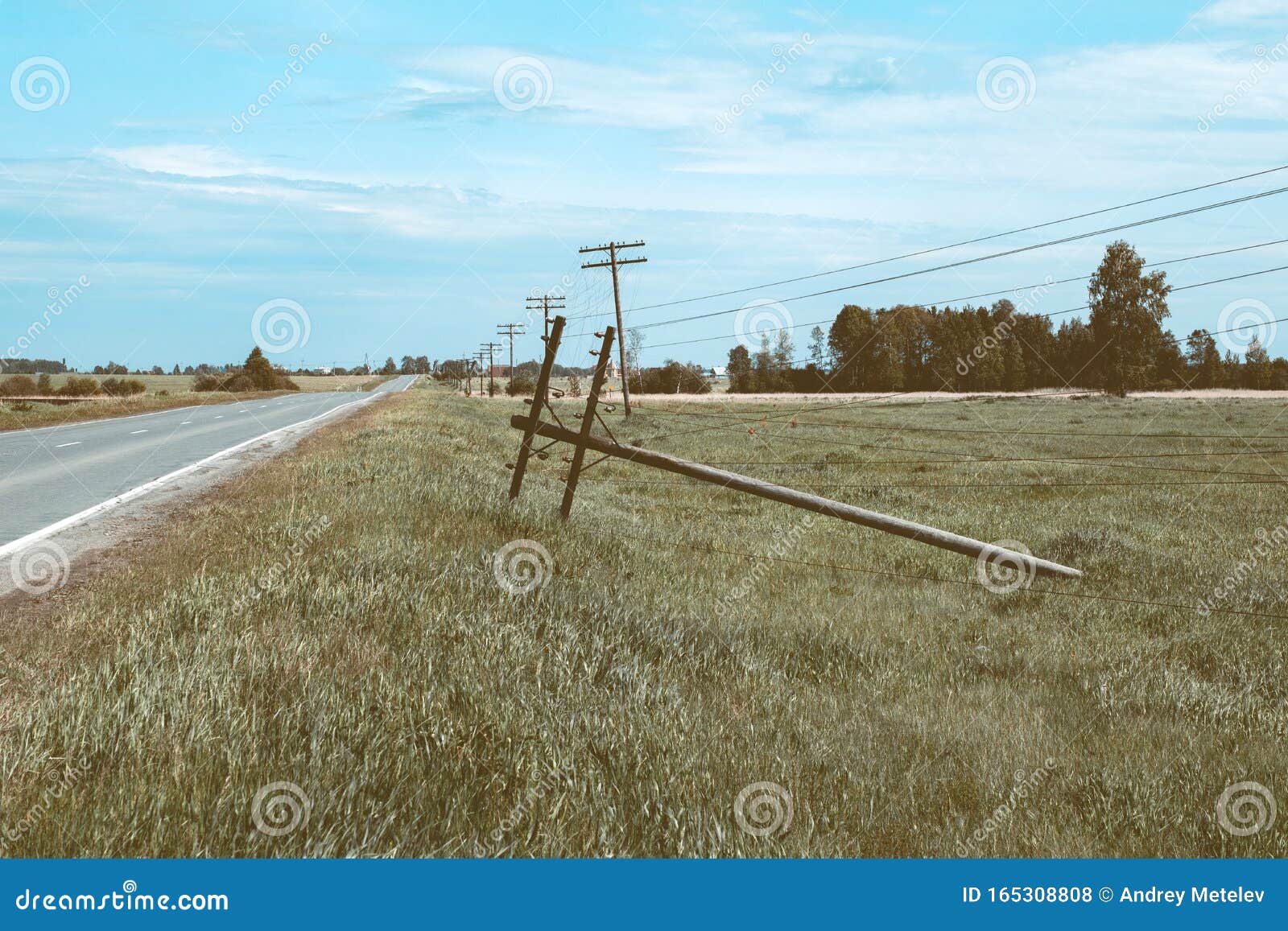 A Pole with Electrical Wires Fell by the Roadside Stock Photo Image