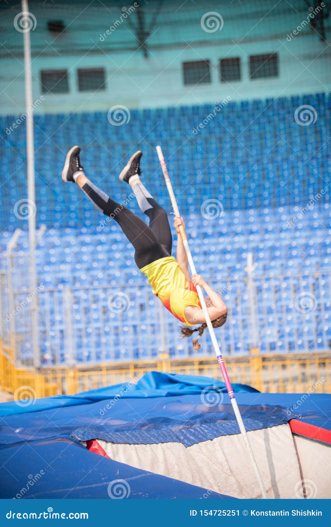 Pole Vault a Female Jumper Falling Down after the Jump in the Stadium