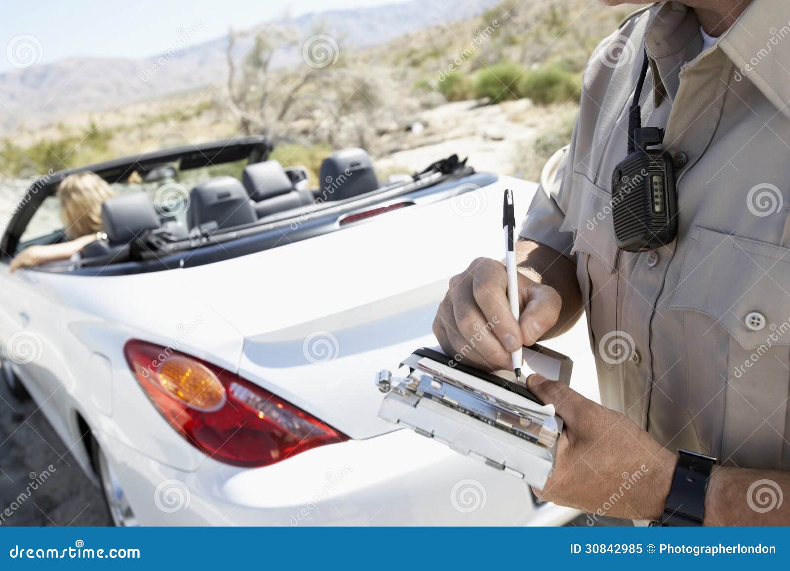 police officer writing traffic ticket to woman sitting in car