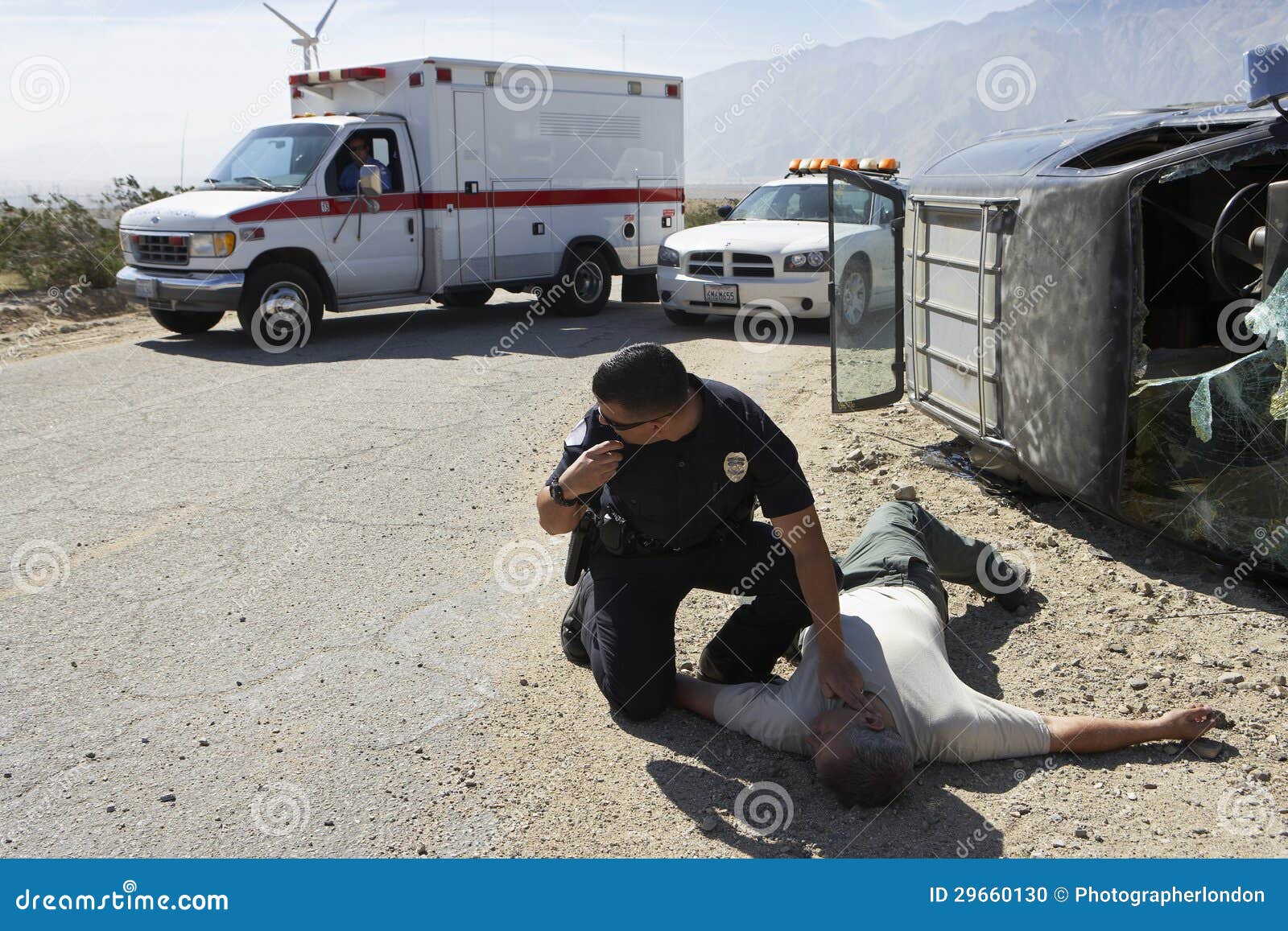 policeman checking pulse of car crash victim