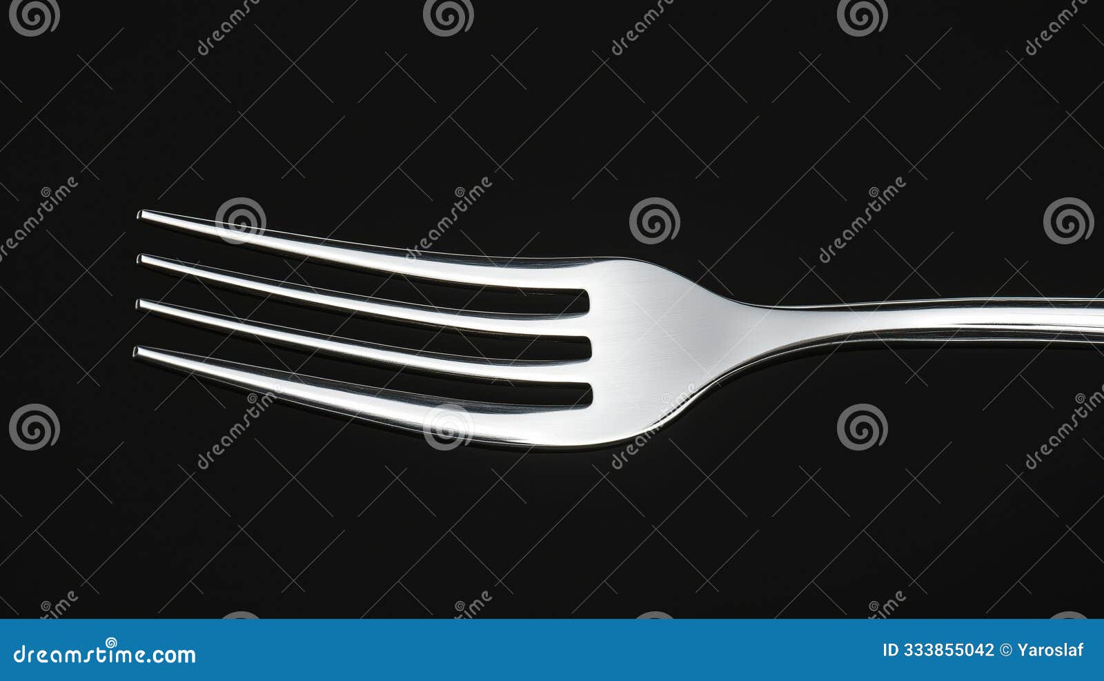 a polished silver fork with four tines elegantly  against a rich black background for culinary 