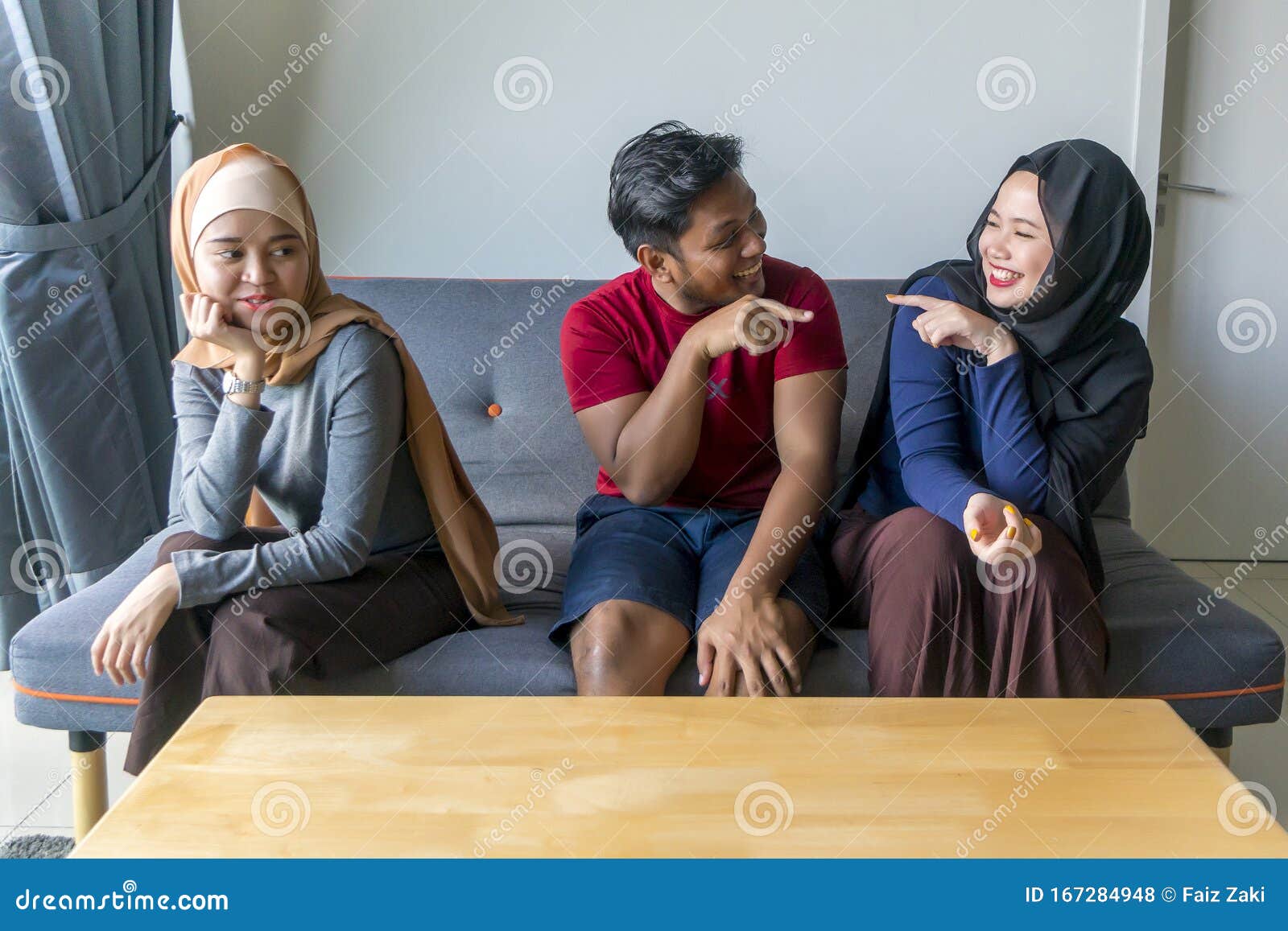 Polygamy Concept Husband With 2 Wife At The Sofa Stock Photo picture