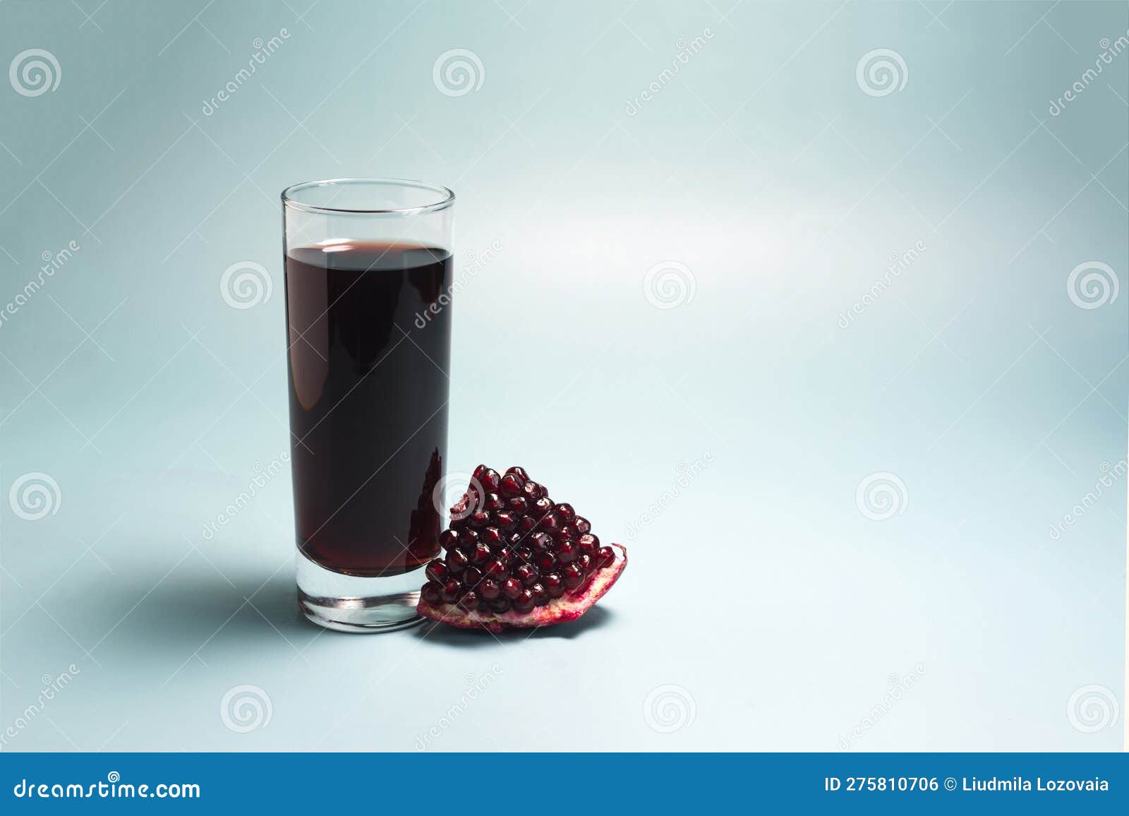 Pomegranate Juice in a Transparent Glass and a Slice of Pomegranate