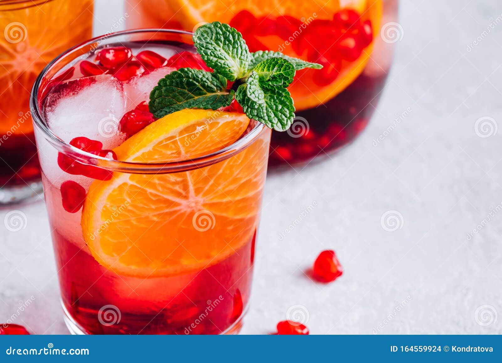 pomegranate orange holiday punch with ice and mint in glass