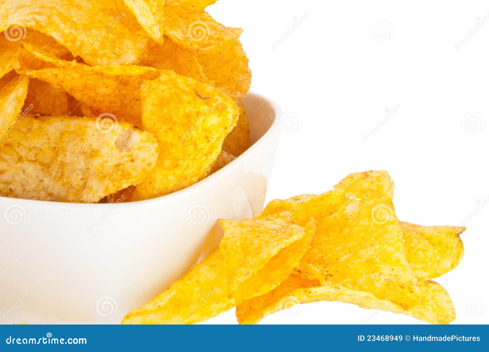 Pommes chips dedans une cuvette (avec le chemin de découpage). Le groupe de pommes chips dedans une cuvette blanche d'isolement sur le fond blanc (avec le chemin de découpage)