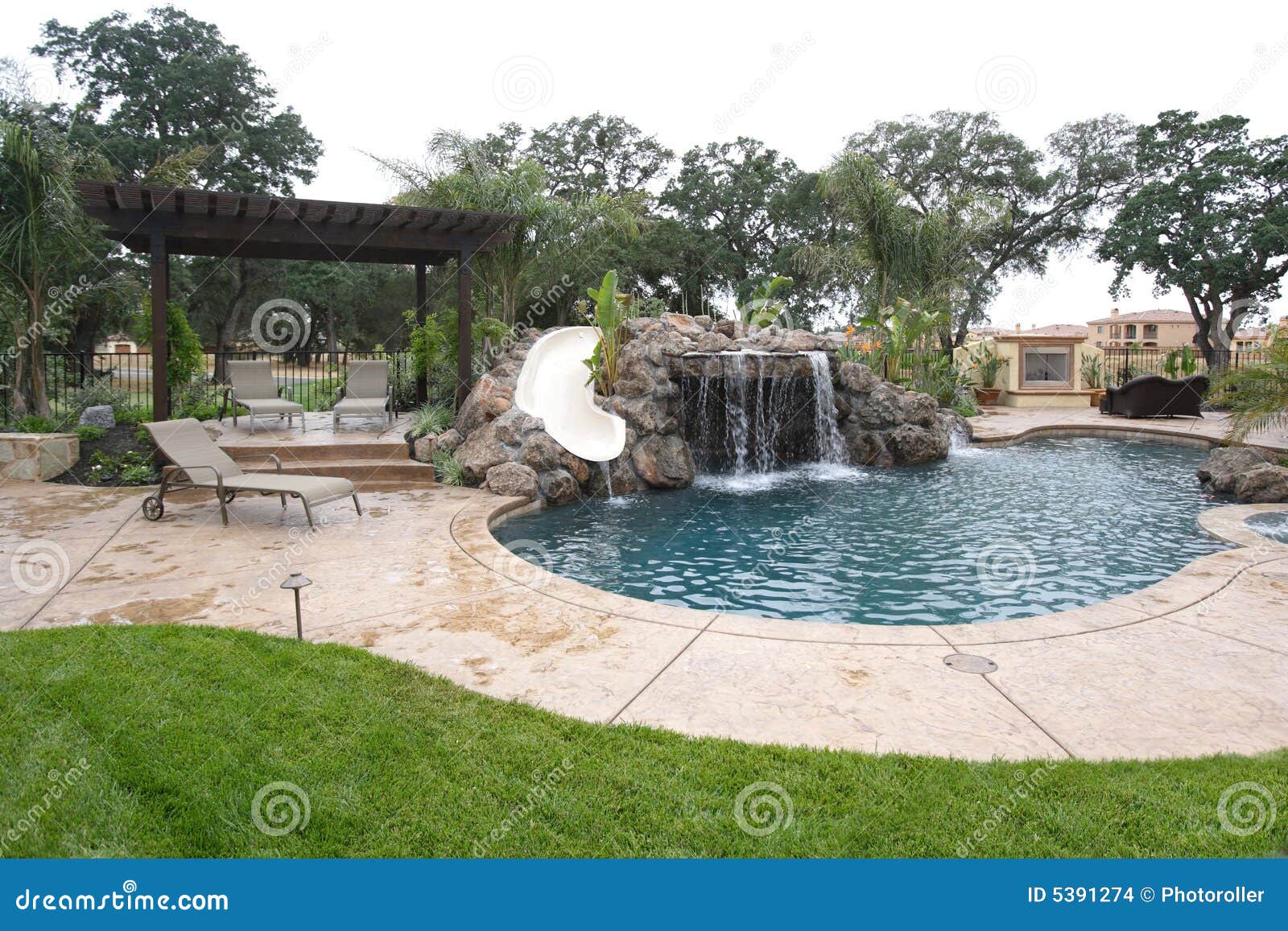 a pool with a waterfall in a luxury backyard