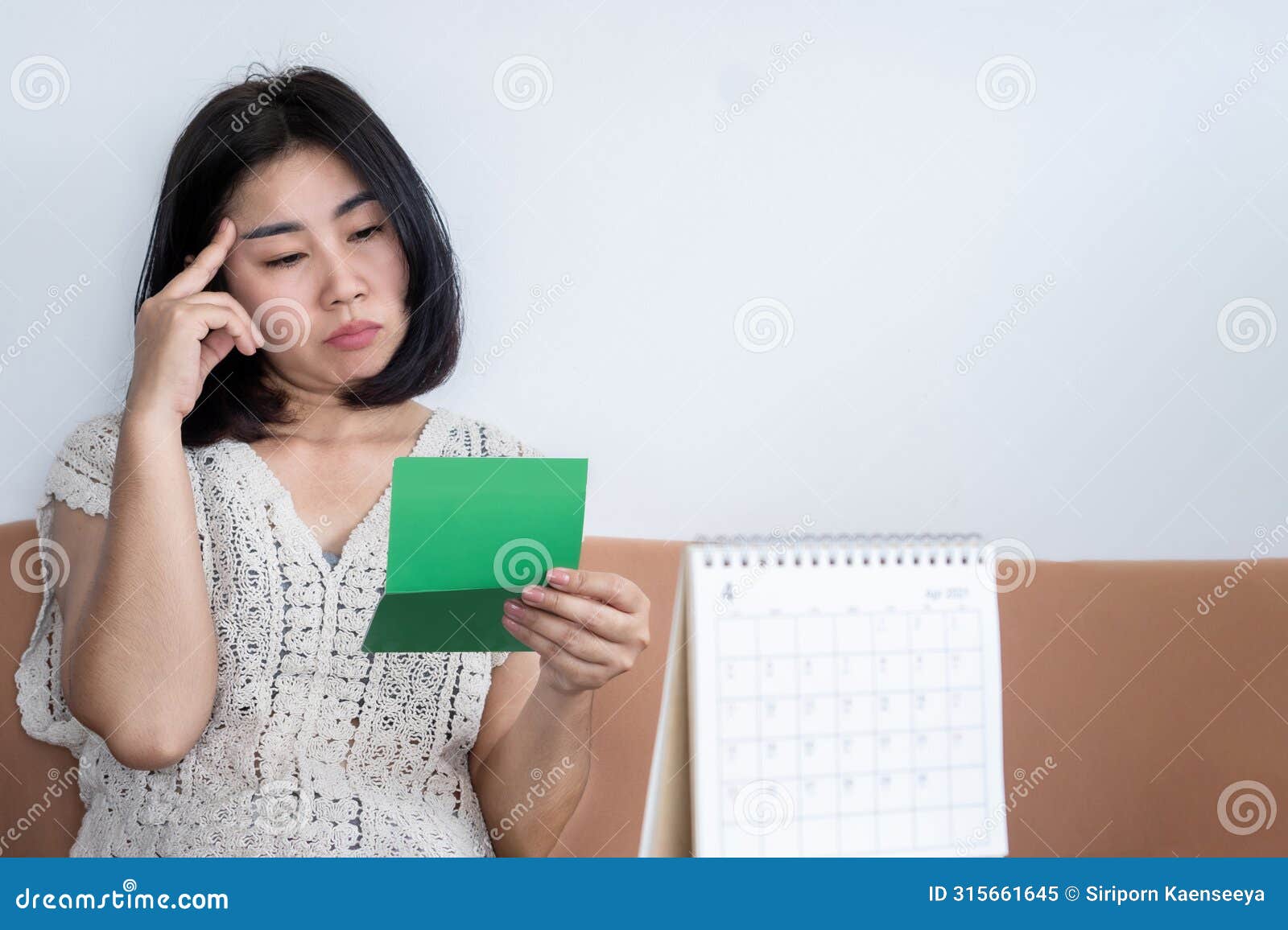 poor bankrupt asian woman checking her money in account book