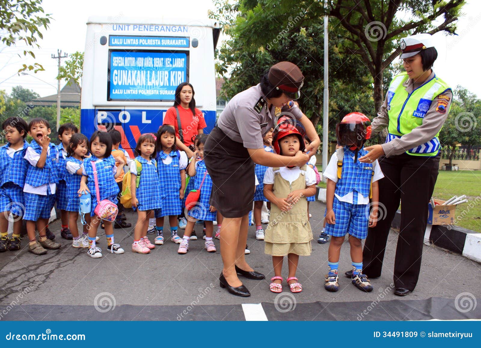 Poprawny sposób być ubranym hełm. Niektóre kobiet policja uczy dziecinów uczni o poprawnym sposobie być ubranym hełm w Polresta, solo