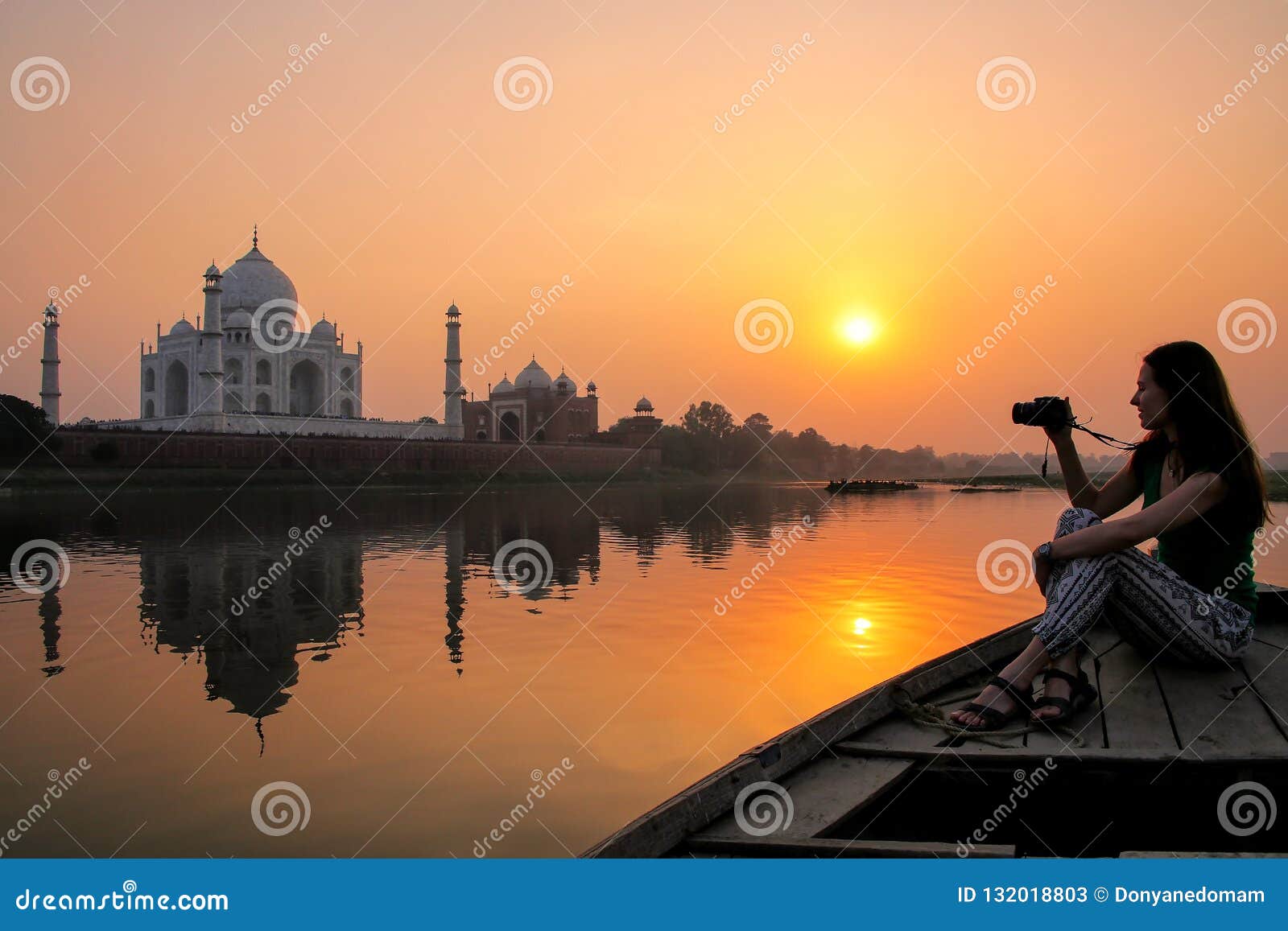 Por do sol de observação da mulher sobre Taj Mahal de um barco, Agra, Índia Era construção em 1632 pelo imperador Shah Jahan como um memorial para sua segunda esposa Mumtaz Mahal