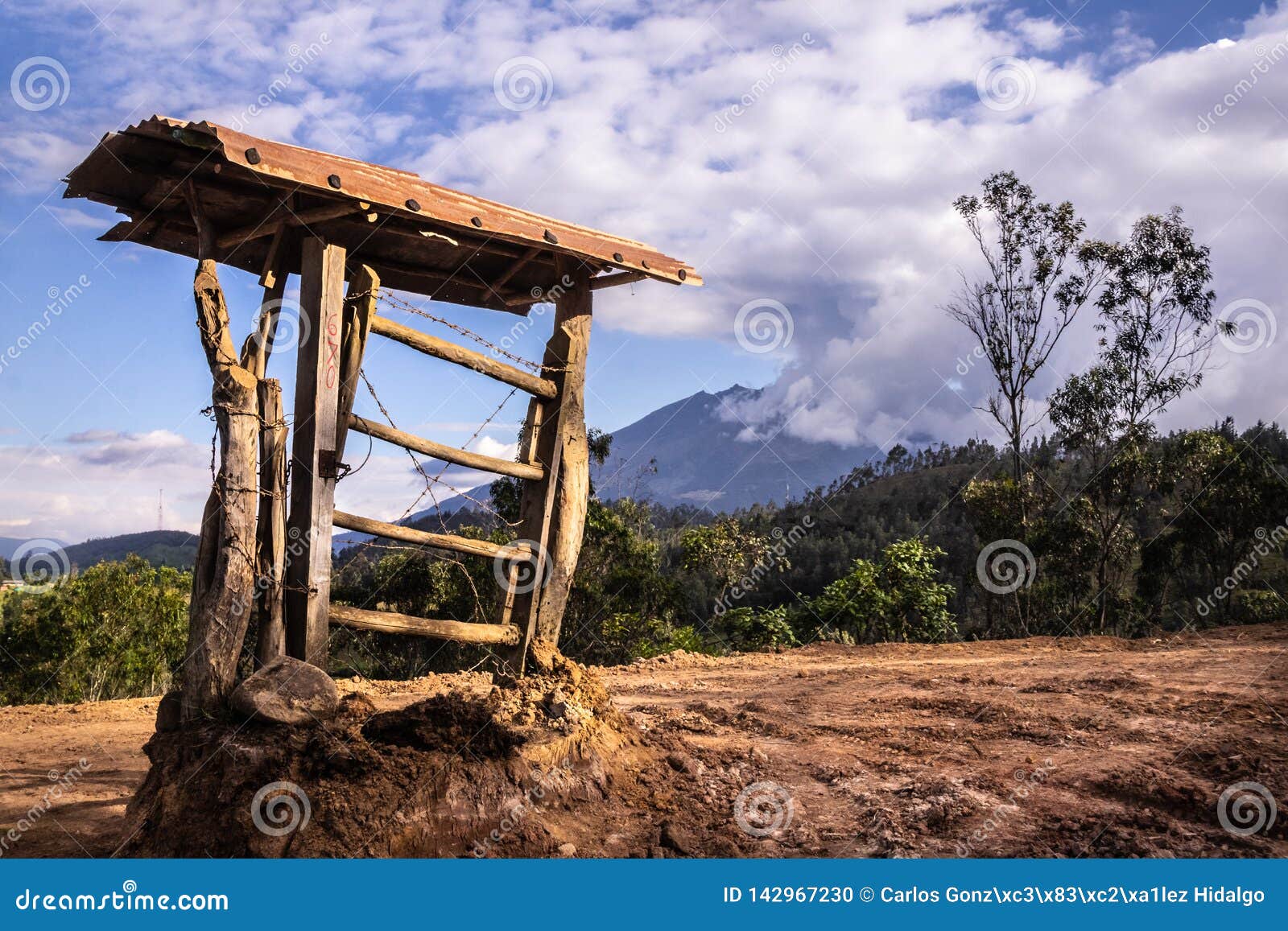 una puerta de campo en un terreno abierto, cerrada con alambres cruzados