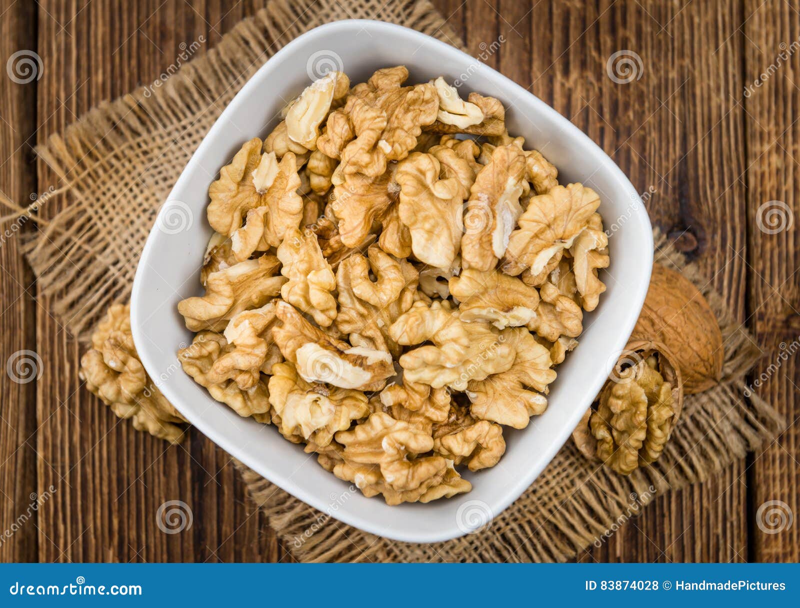 Porción de nueces agrietadas en foco selectivo del fondo de madera. Los corazones de las nueces en una tabla de madera vieja como primer detallado tiraron el foco selectivo