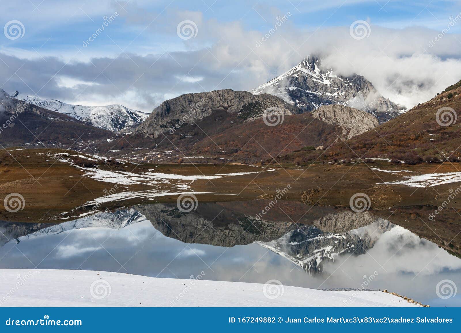porma reservoir, susaron peak snowy and its reflection in the water. lion. spain