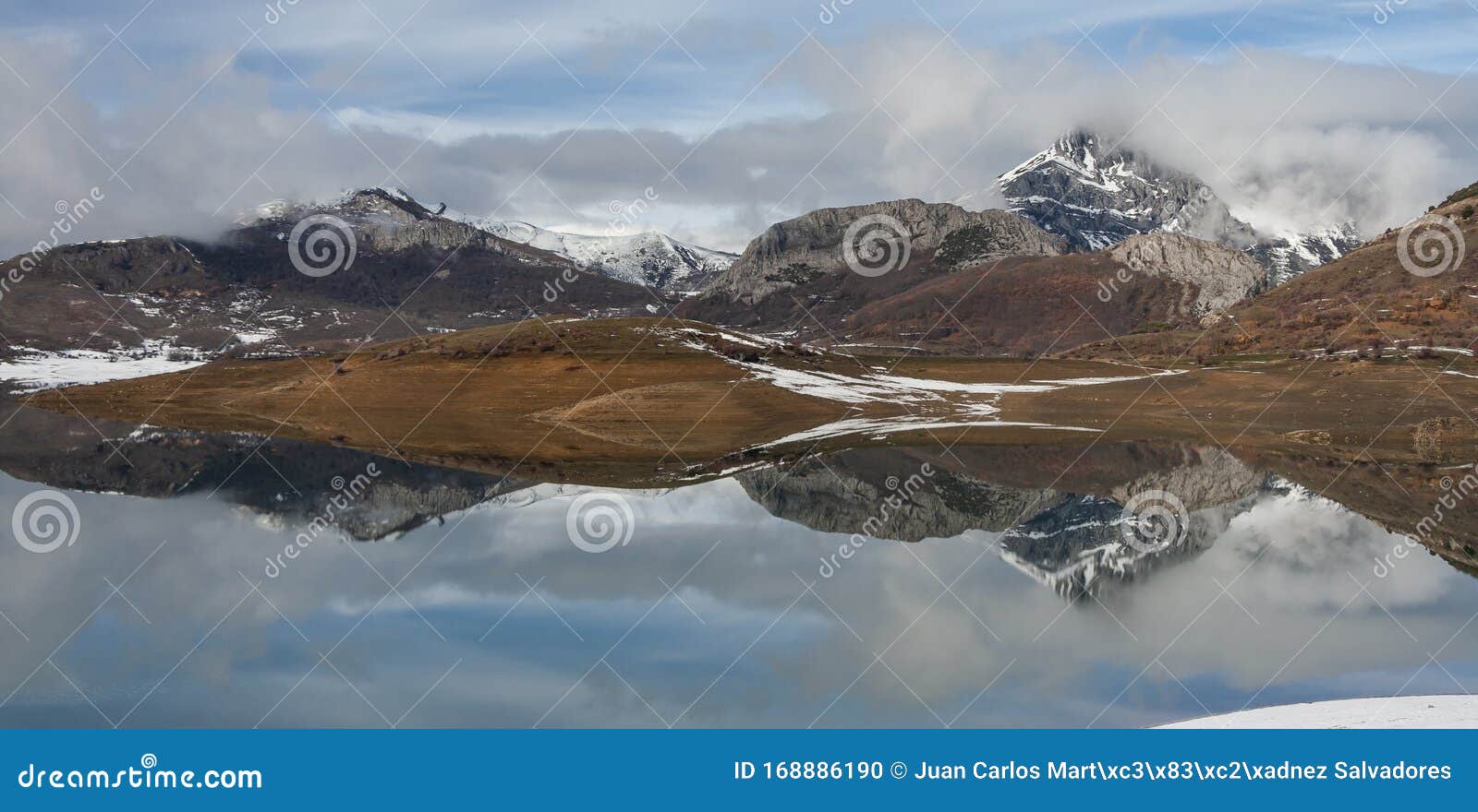 porma reservoir, susaron peak snowy and its reflection in the water. lion. spain