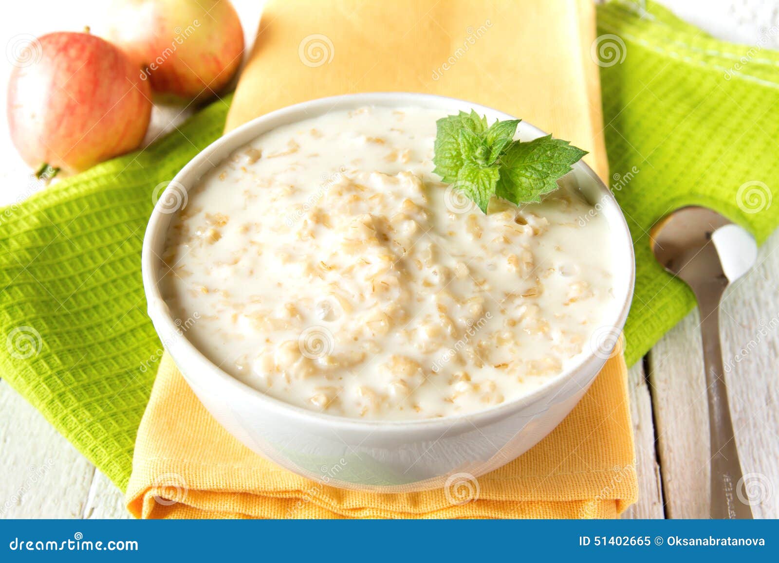 Porridge della farina d'avena. Porridge semplice caldo fresco della farina d'avena con la menta sul tovagliolo e sulla tavola di legno Prima colazione vegetariana sana naturale, fine su, orizzontale