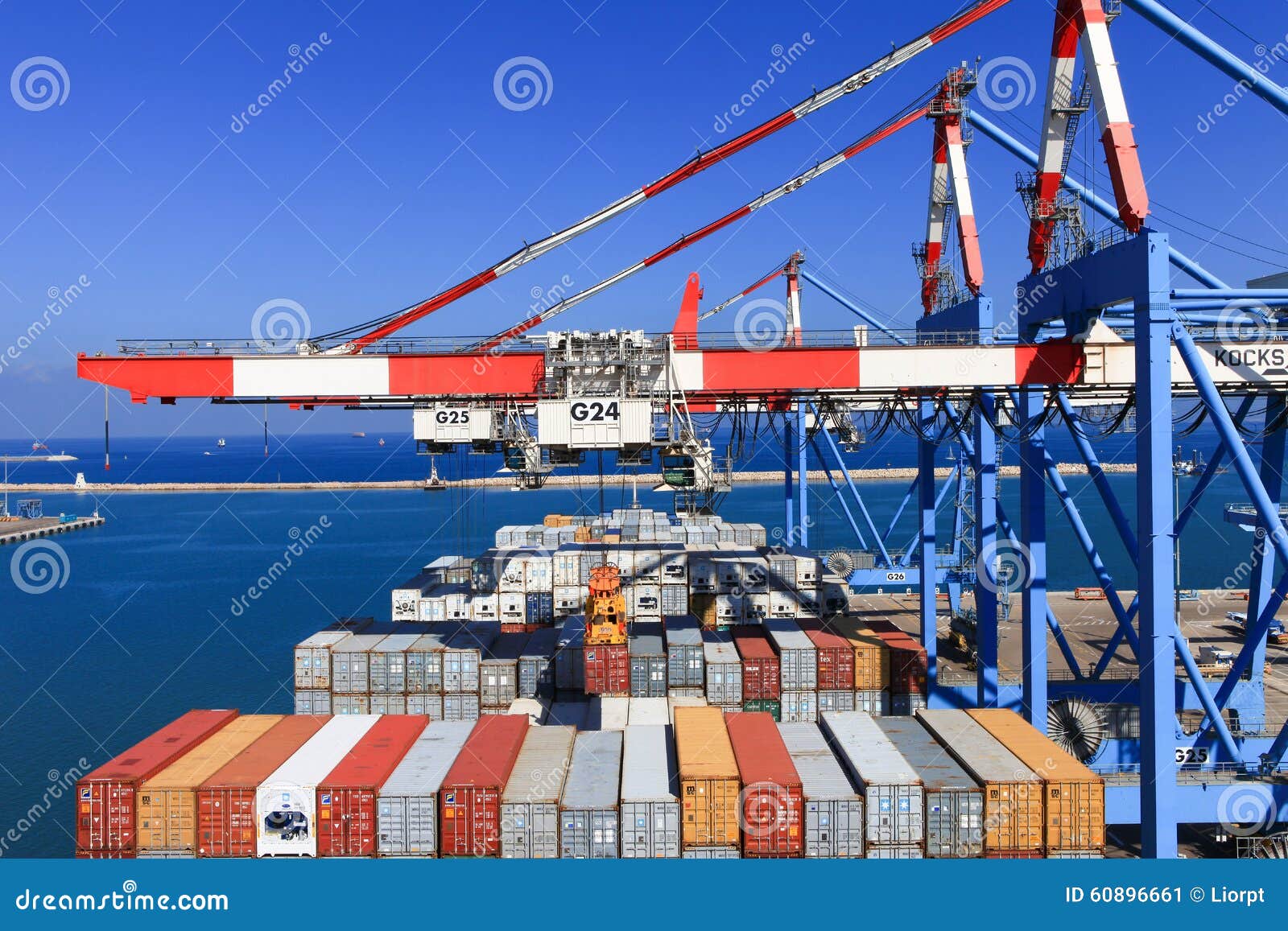 Port dock with container ship and Various brands and colors of shipping containers stacked in a holding platform waiting for loading.