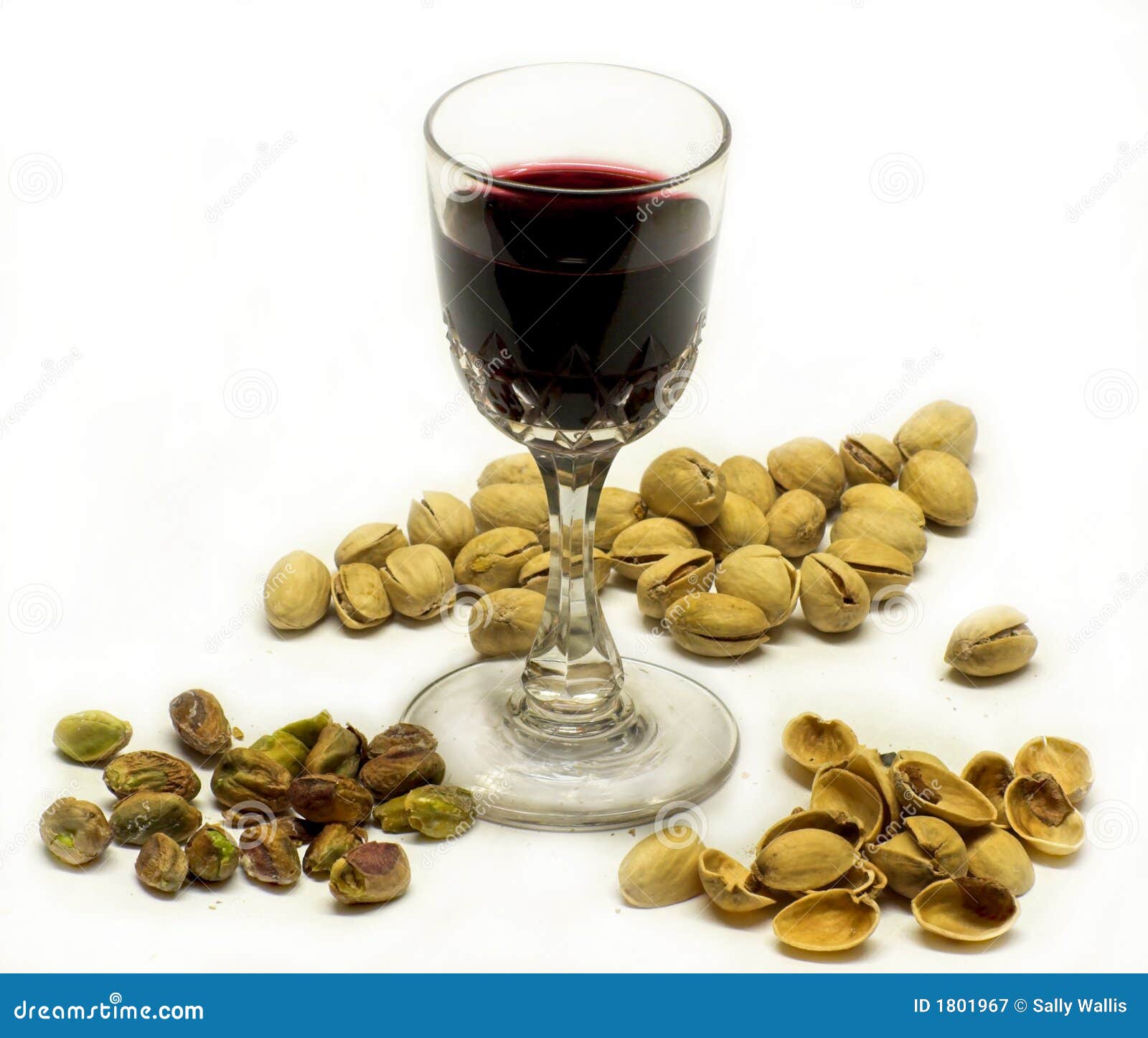 Port &amp; Pistachios. Glass of port surrounded by pistachio nuts, some shelled, some in the shells, and empty shells