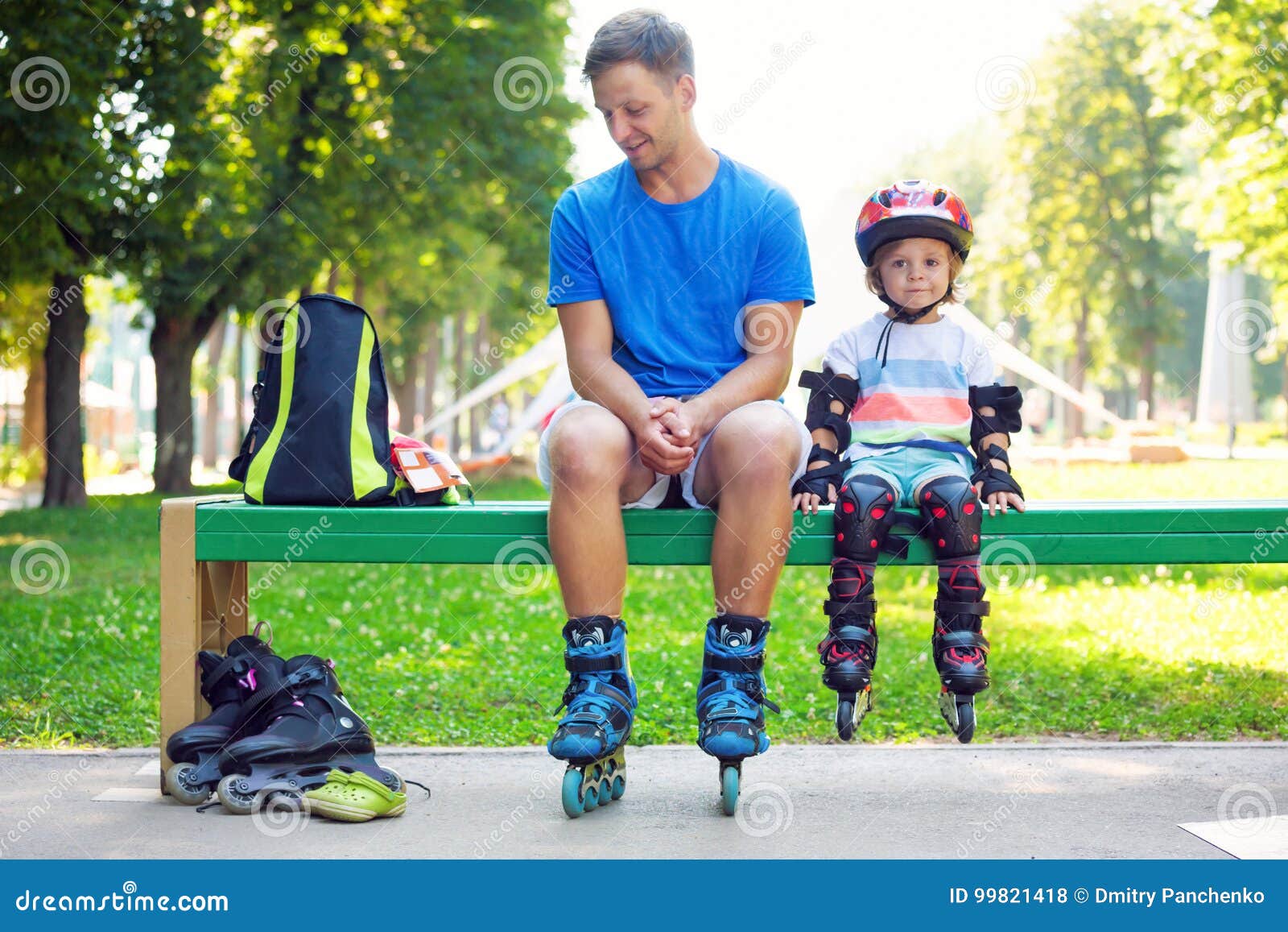 portait of cute baby boy with inline skating instructor.