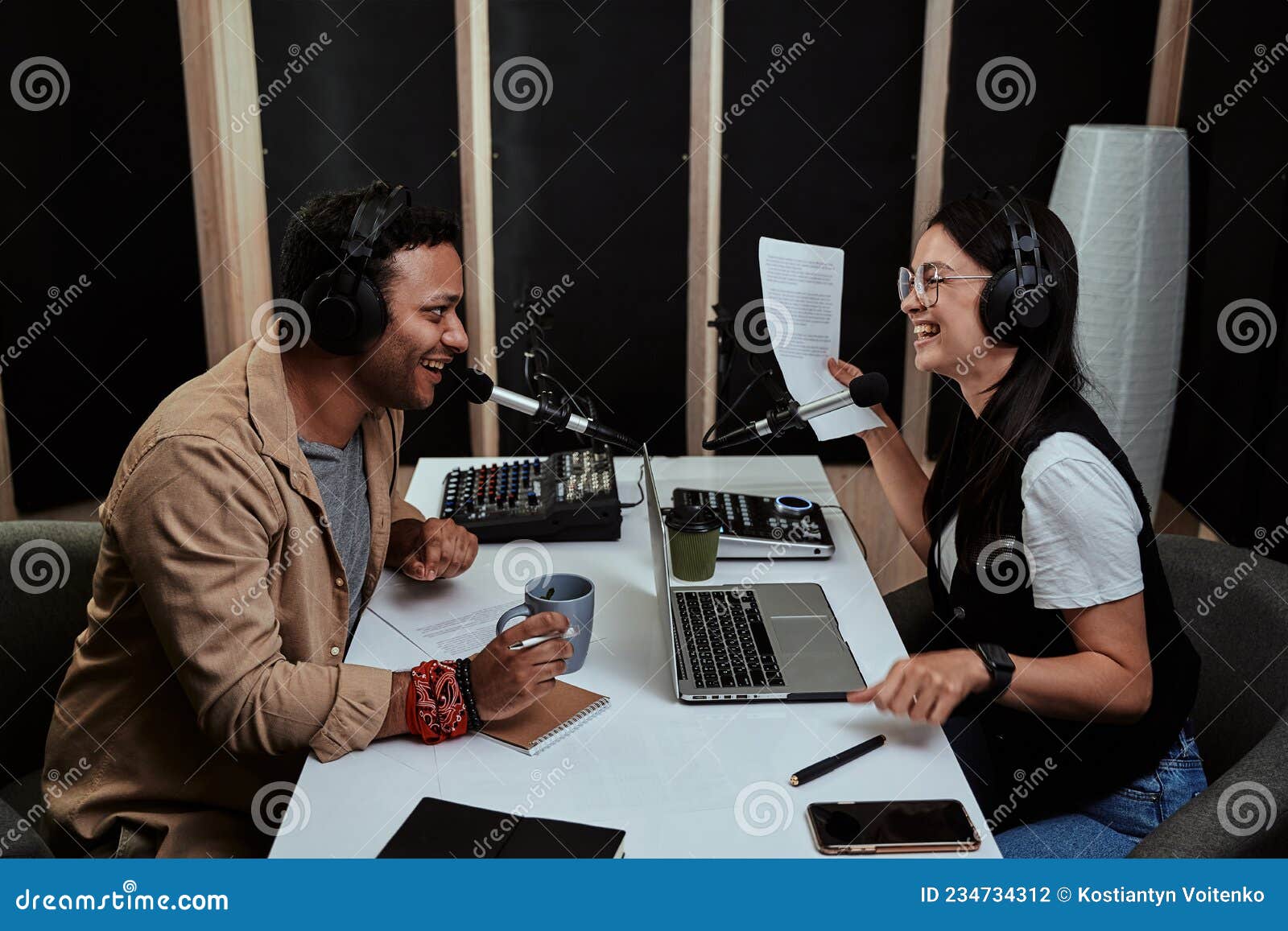 portait of two cheerful radio hosts, young man and woman laughing while discussing various topics, moderating a live