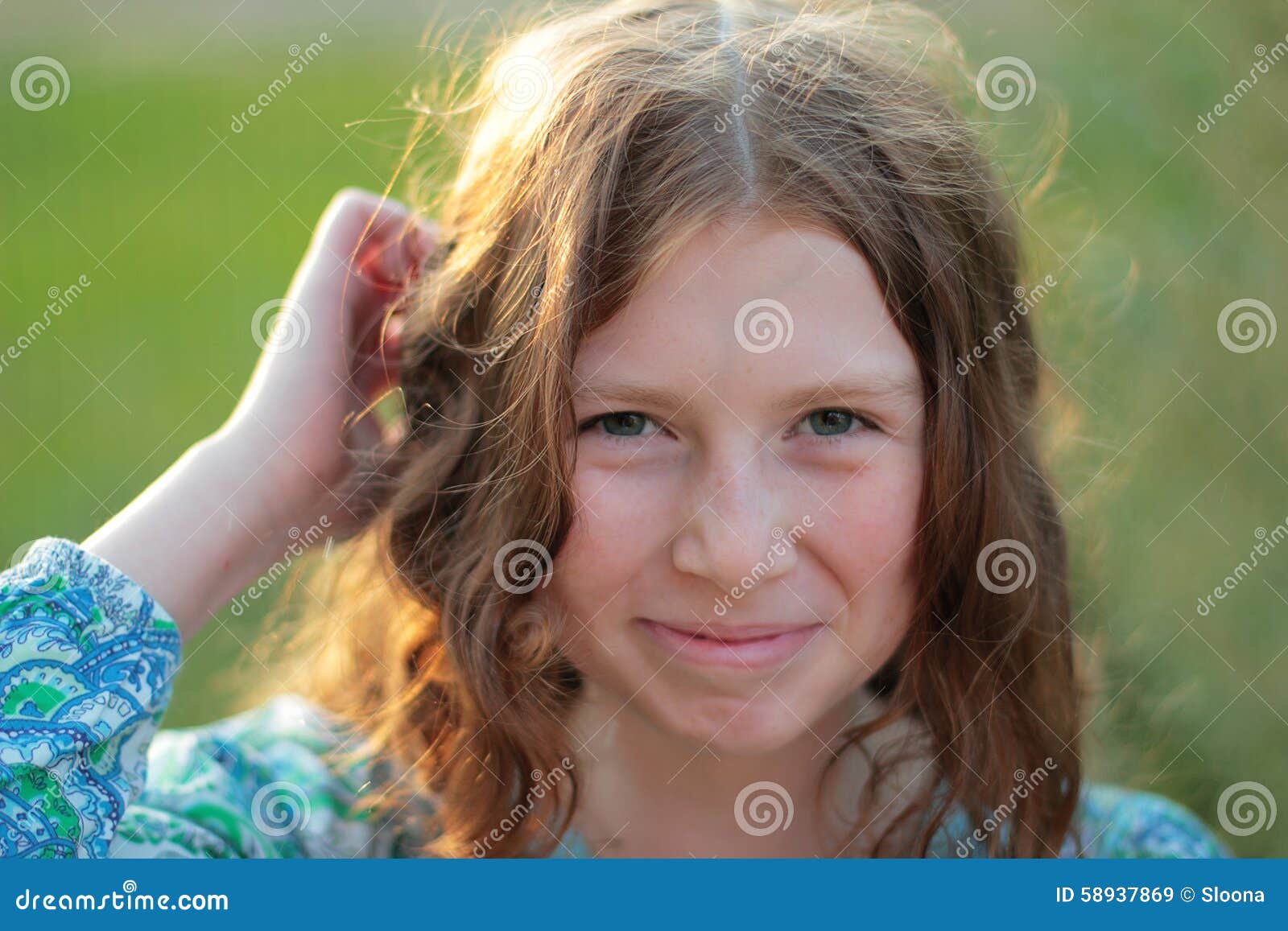 portarit of laughing curly girl  on green nature background