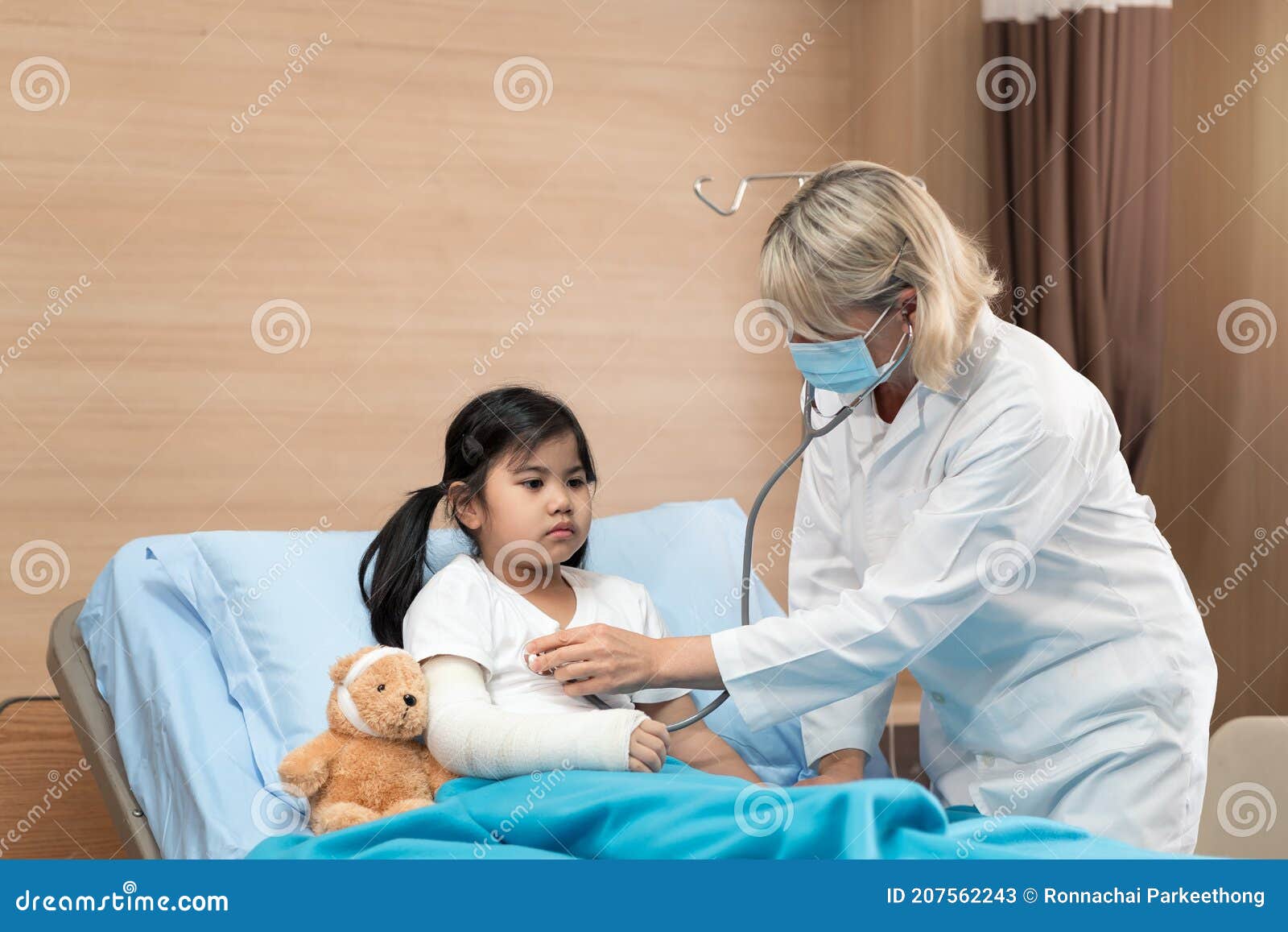 portarit of smaile doctor pediatrician and little girl patient on bed