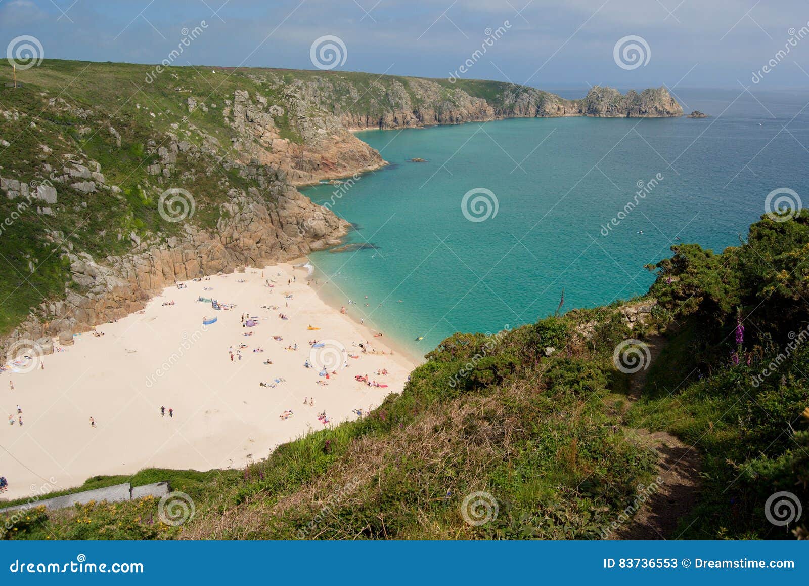 Porthucrno sandy beach and summer in the cornwall, UK. Porthcurno sandy beach with tourists, rocks of the coast in background, pure water of the celtic sea, view from the Minack Theatre, summer in the Cornwall, UK 6/2016