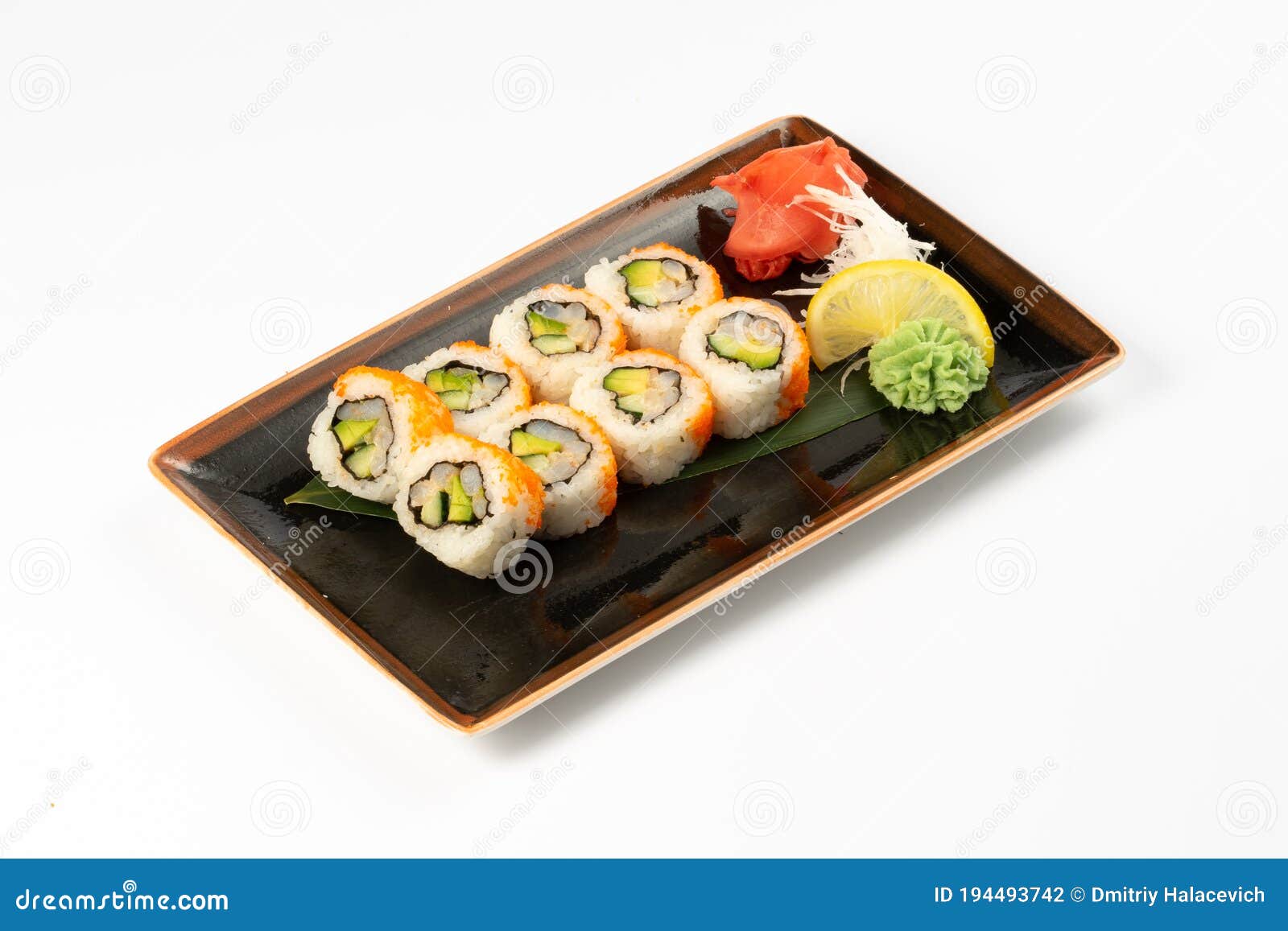 A Portion Of Maki Sushi With An Assortment Of Japanese Side Dishes In A
