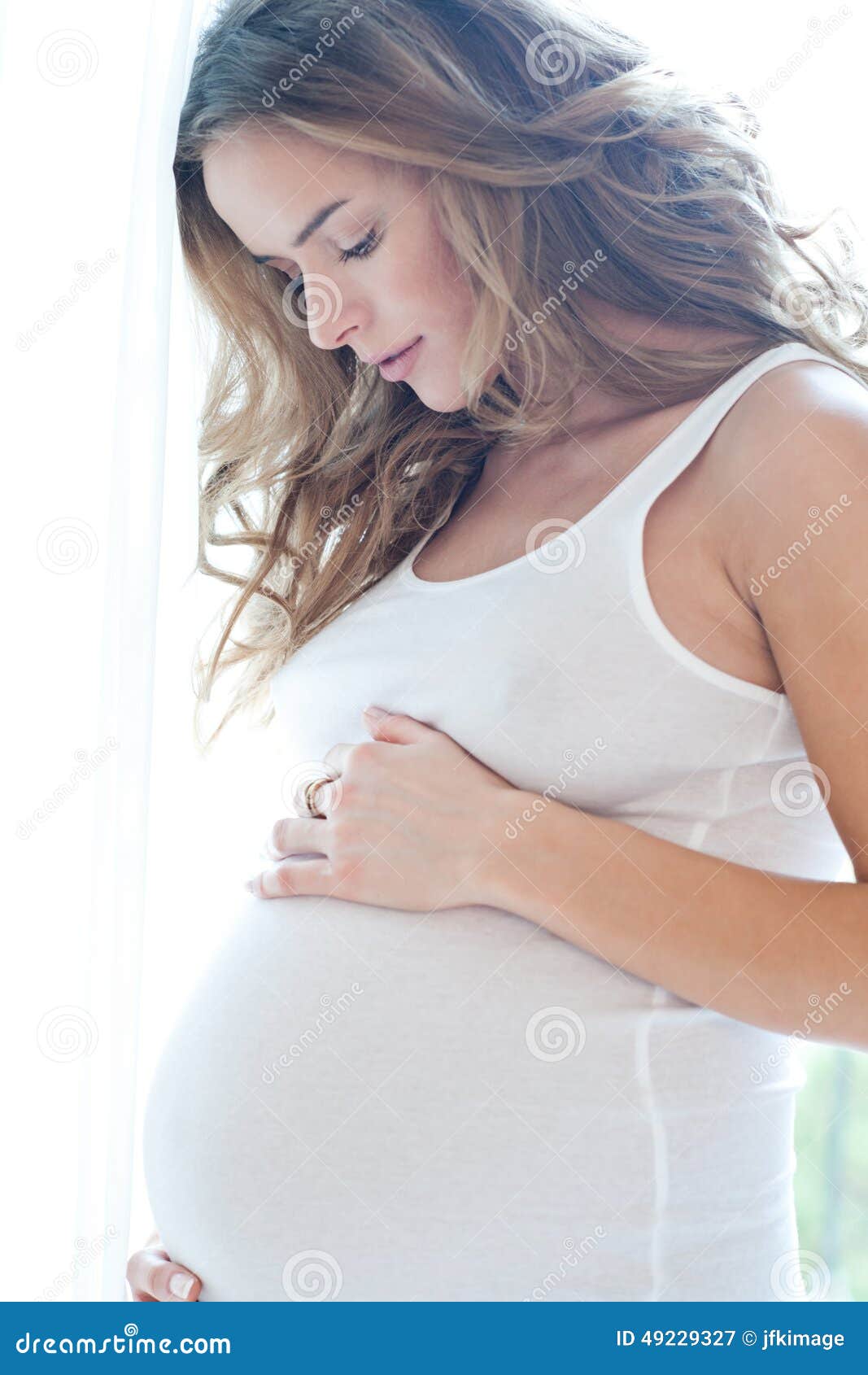 portrait of adorable pregnant woman in white