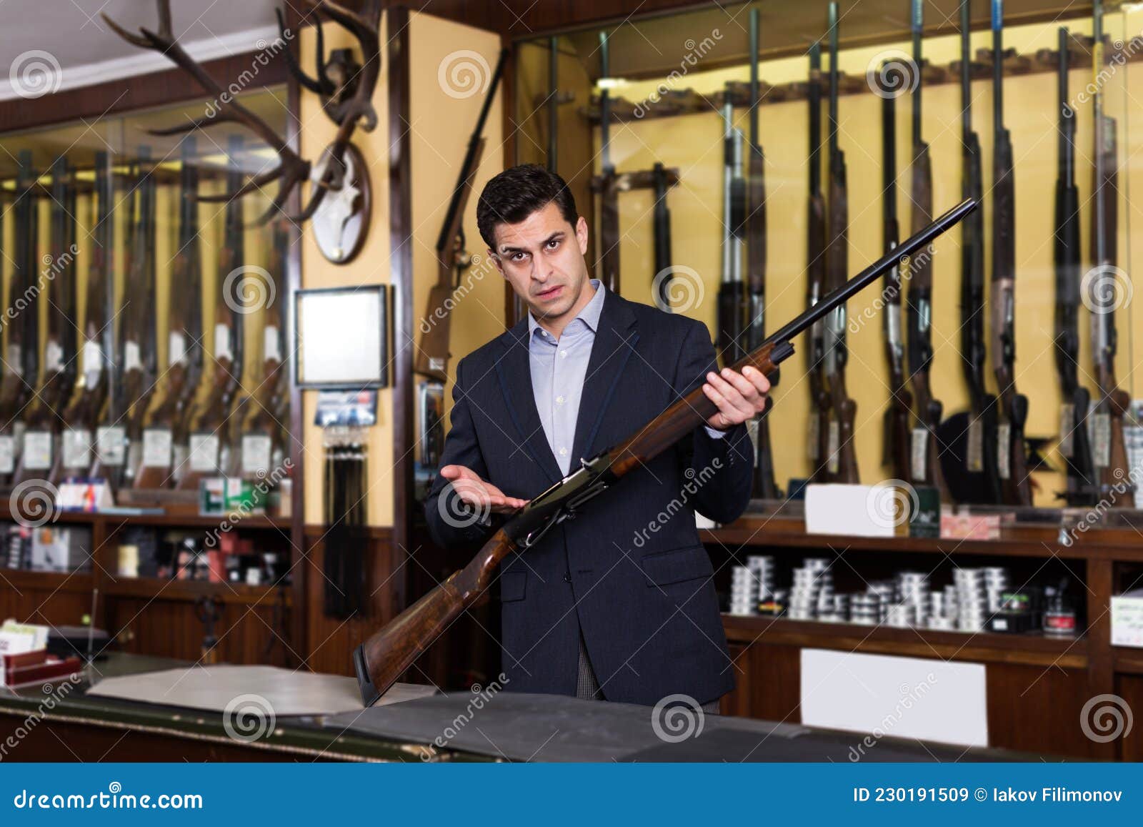 Weapon Seller In The World Of Magic Adult Male Seller in Gun Shop Demonstrating Shotgun Stock Image - Image