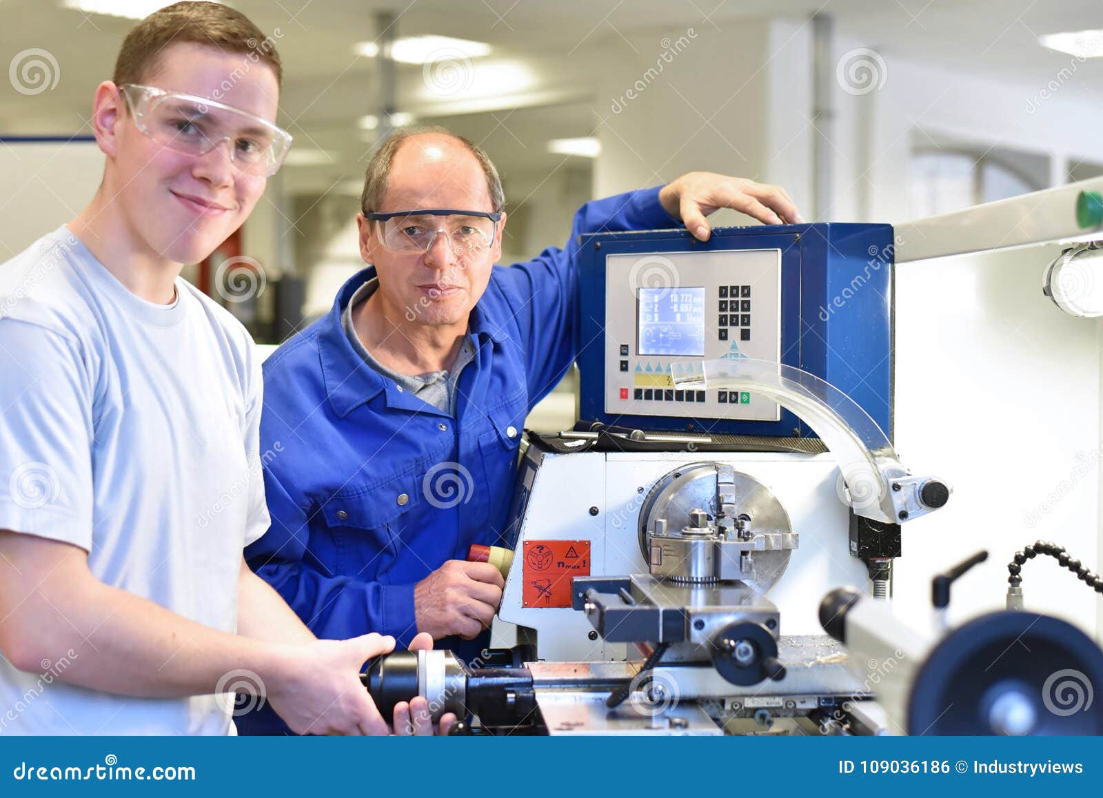 portrait apprentice and teacher in vocational training at a cnc