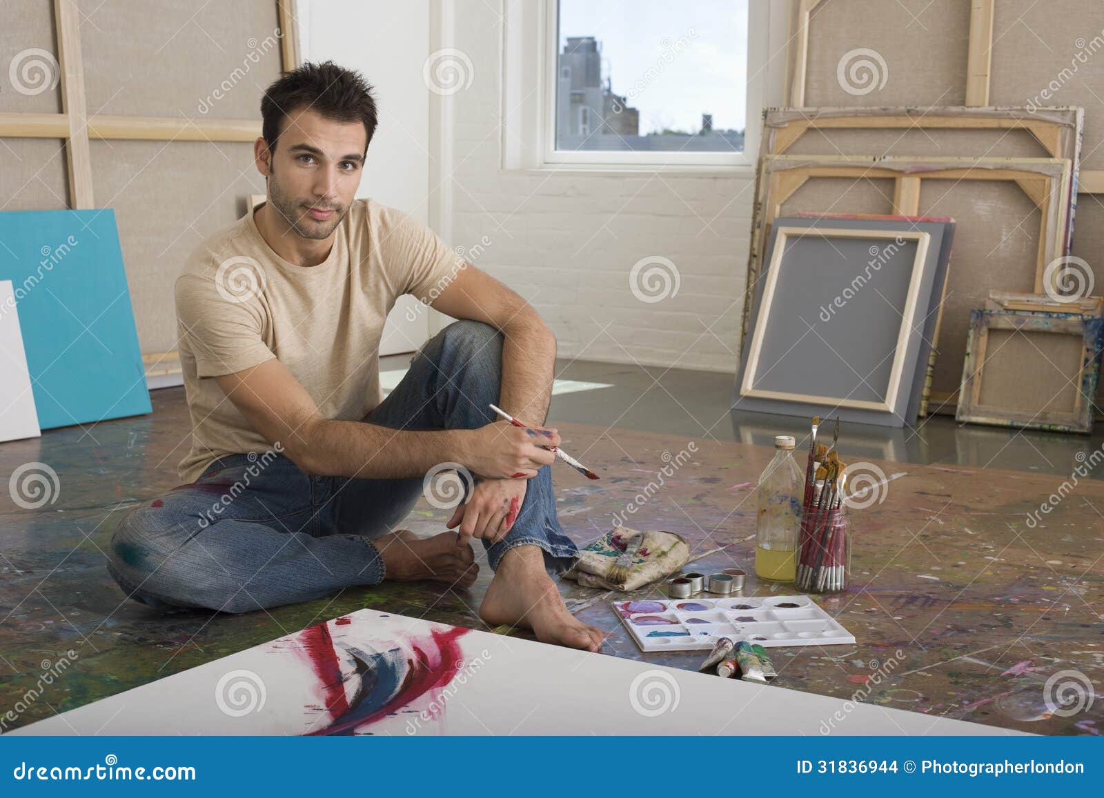 portrait of artist with painting tools in studio