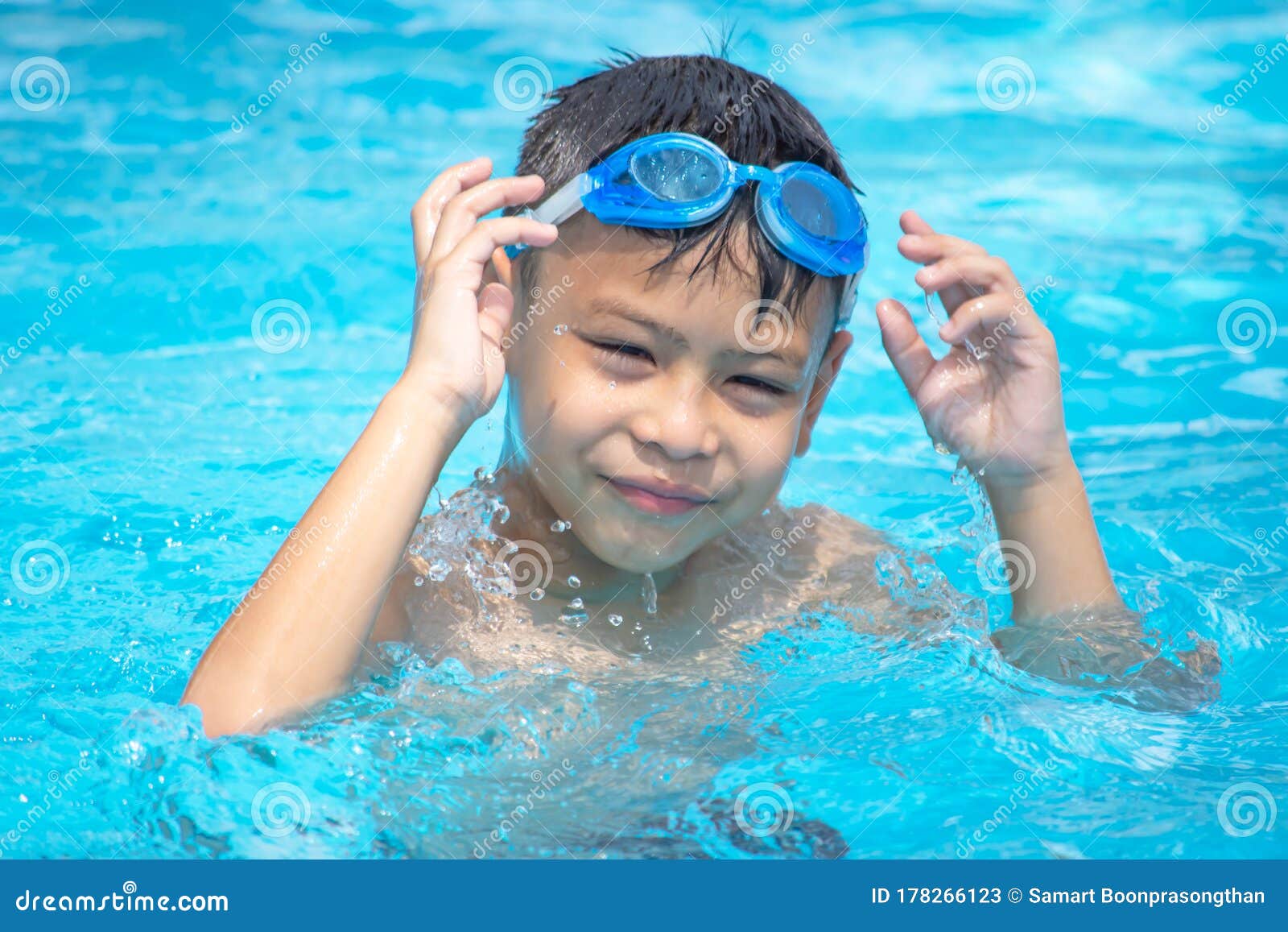 Portrait of smiling shirtless boy with swimming goggles in 