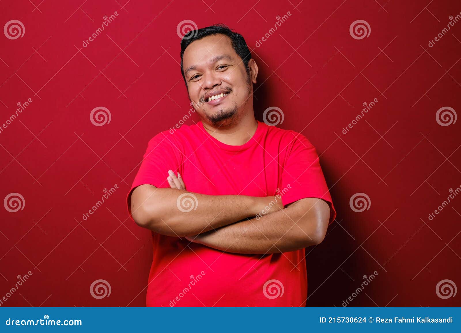 portrait of asian handsome man with arms crossed isolate on red background