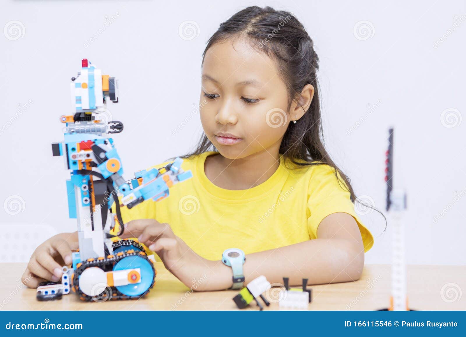 portrait of asian kid constructing a robot