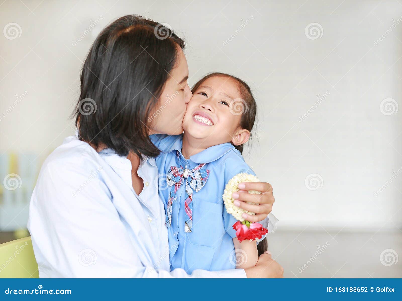 Portrait Of Asian Mom Kissing And Hugging Her Daughter On