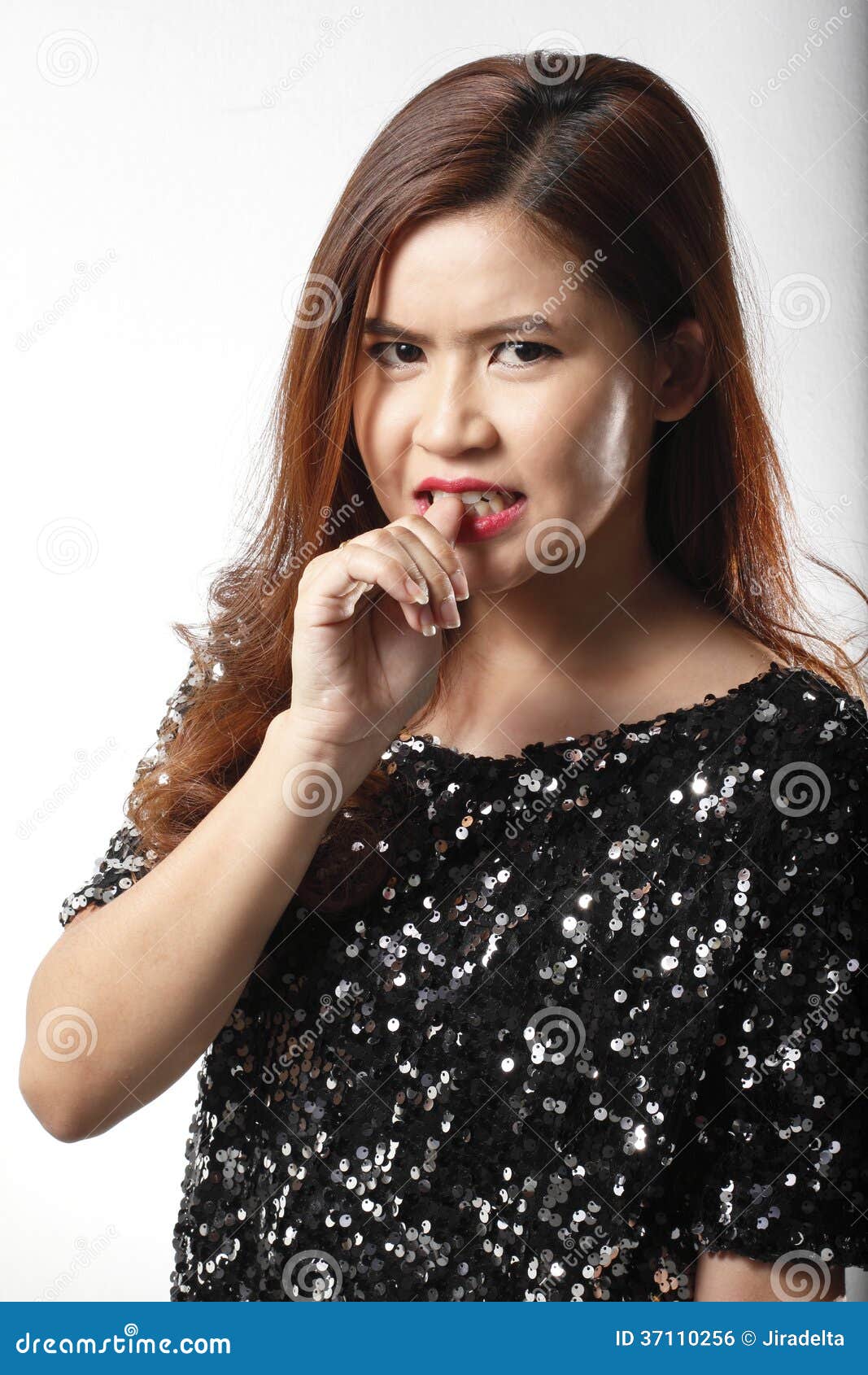 portrait of asian woman in black sequin shirt nip her finger