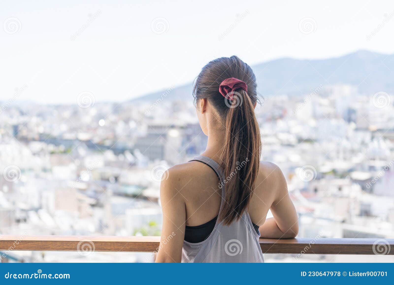 Portrait of an Asian Woman with Sportswear Standing on the Balcony